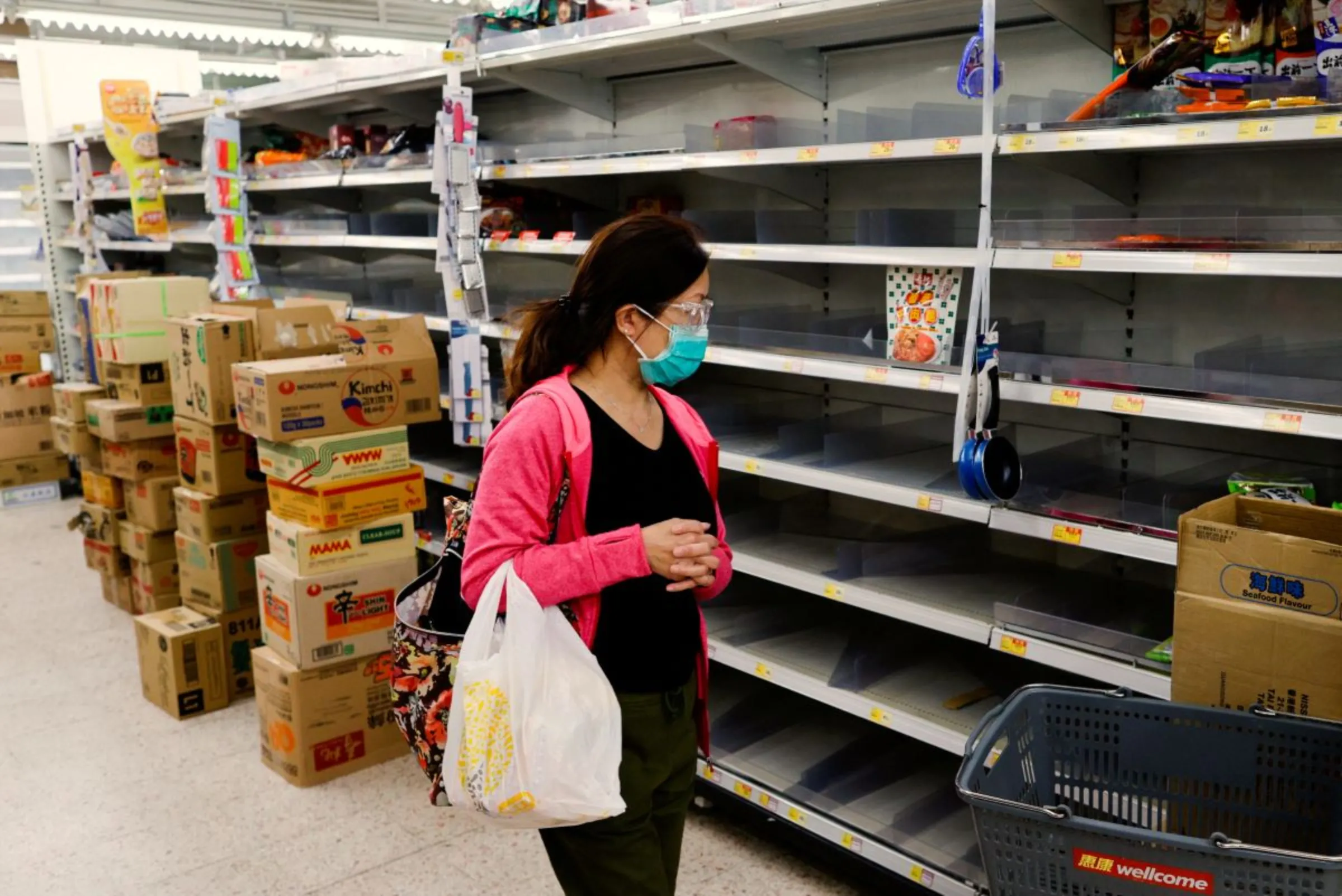 A customer wearing a face mask shops in front of partially empty shelves at a supermarket, ahead of mass coronavirus disease (COVID-19) testing, in Hong Kong, China March 4, 2022. REUTERS/Tyrone Siu