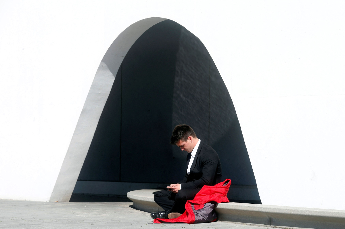 A man uses his mobile phone near the entrance to Mobile World Congress in Barcelona