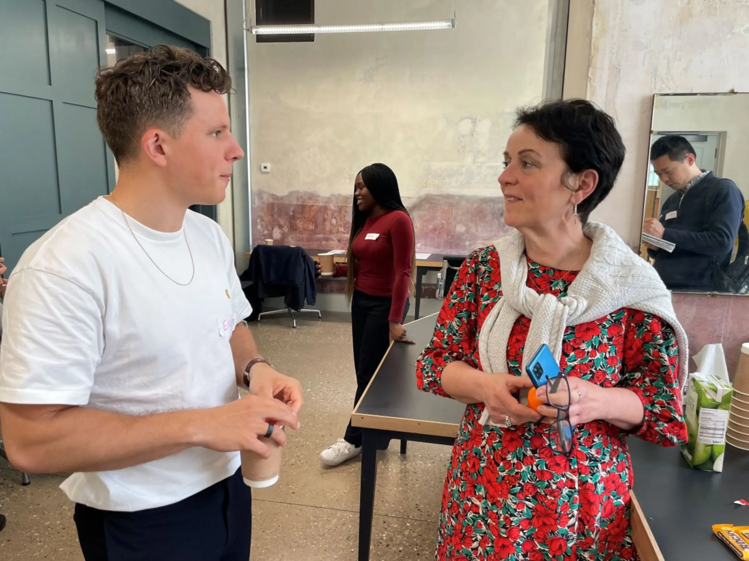 Judi Gasser, Wandsworth Council's cabinet member for the environment, talks to a participant in the London borough’s citizen’s assembly on air quality, April 28, 2023. Thomson Reuters Foundation/Laurie Goering