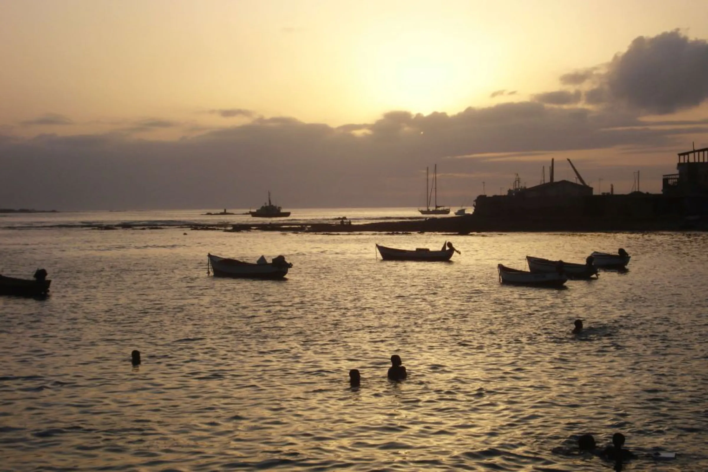 Children play in the water at sunset in the port of Sal Rei, the main town of Cape Verde's Boa Vista island, July 15, 2010