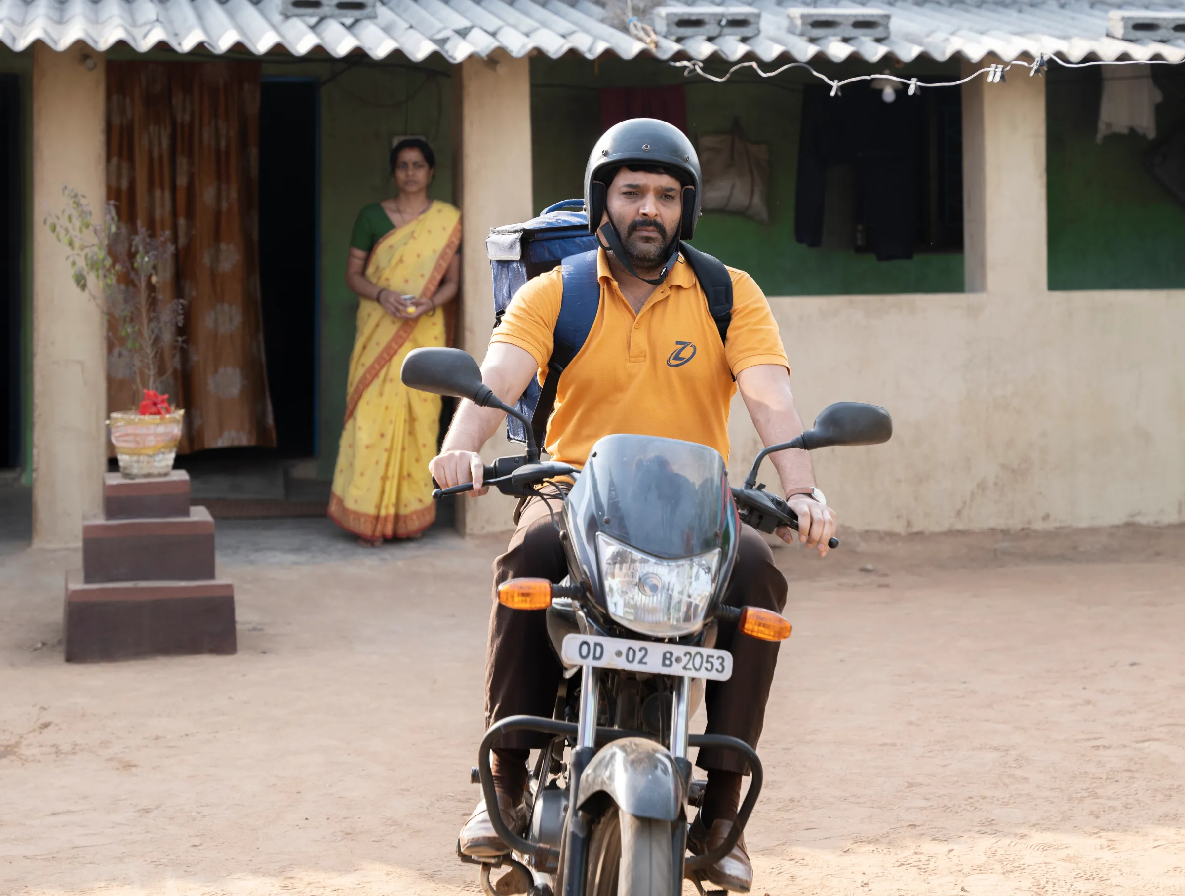 A still image of a man on his scooter from the Bollywood film 'Zwigato' starring Kapil Sharma, that tells the story of a food-delivery app driver's struggle in the eastern city of Bhubaneswar, India. Applause Entertainment/Handout via Thomson Reuters Foundation