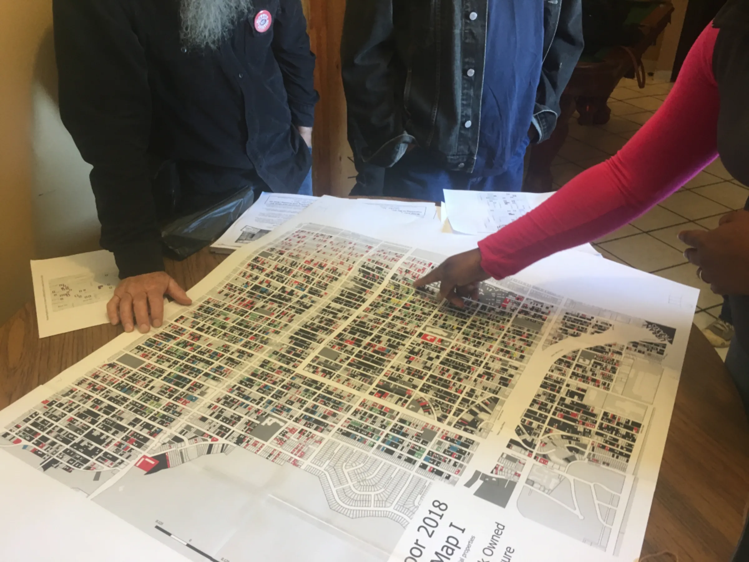 Local residents and organizers look at a property ownership map in Detroit in 2019. Property Praxis/Handout via Thomson Reuters Foundation