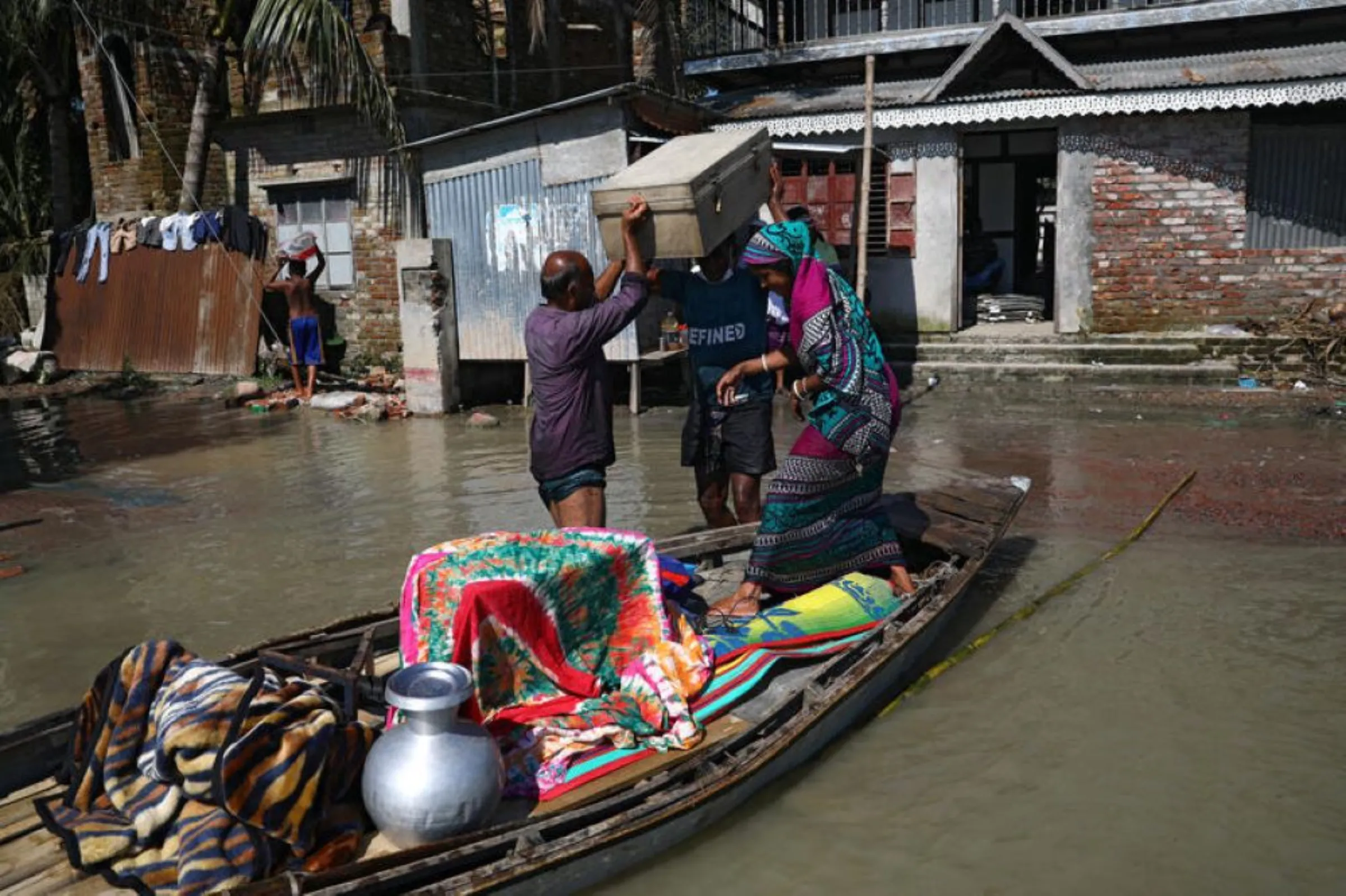 A family moves to a safe place with their belongings after the flood situation worsened in Munshiganj district, on the outskirts of Dhaka, Bangladesh, July 25, 2020