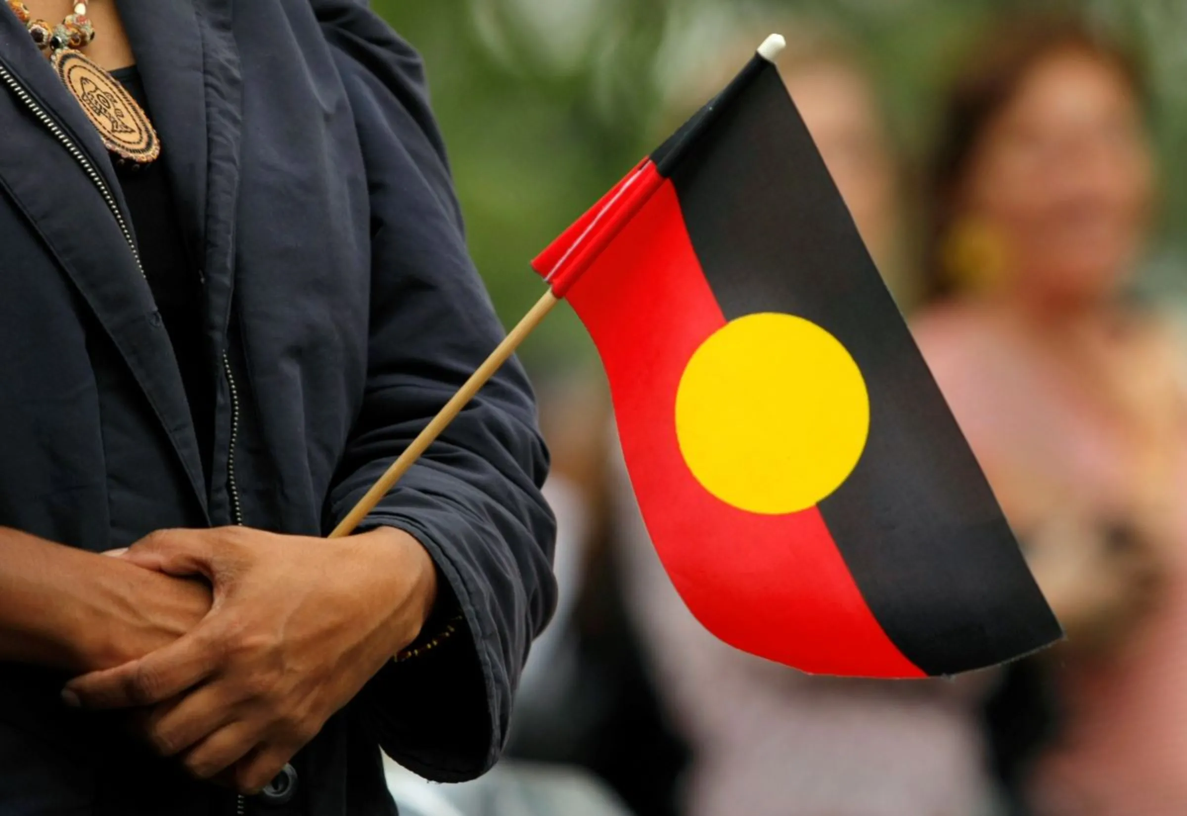 A woman holds an Aboriginal flag in the central Sydney suburb of Redfern, the heart of the nation's aboriginal rights movement. REUTERS/Tim Wimborne