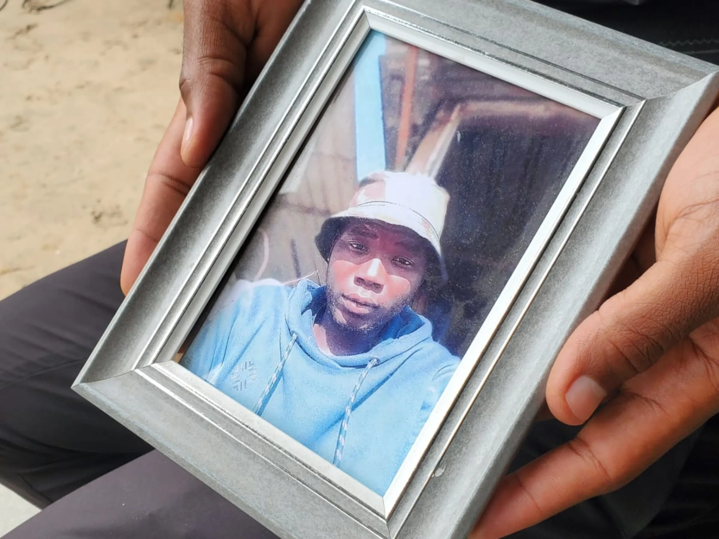 A photograph of Pinto Vasco, who died by suicide after incurring high gambling debts, held by his brother, João Vasco, Maputo, Mozambique, November 8, 2025.  Thomson Reuters Foundation/Samuel Comé