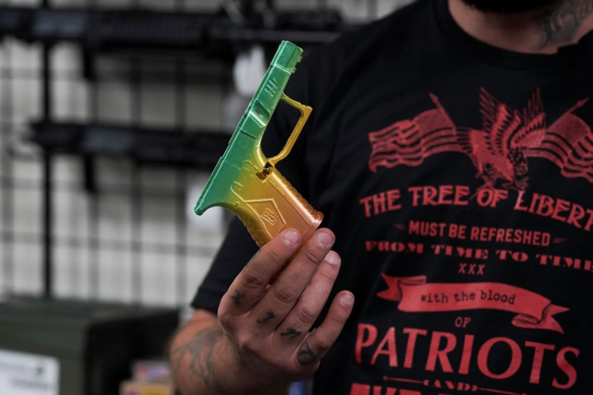 A man shows a custom 3D-printed lower receiver for a Glock pistol inside Firearms Unknown, a gun store in Oceanside, California, U.S., April 12, 2021. REUTERS/Bing Guan
