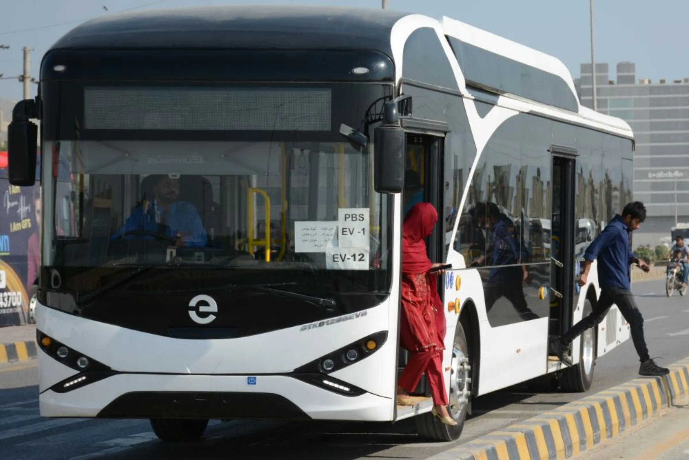Passengers are getting off an electric bus in the neighbourhood of Defense Housing Authority (DHA), Karachi, Pakistan, March 5, 2023