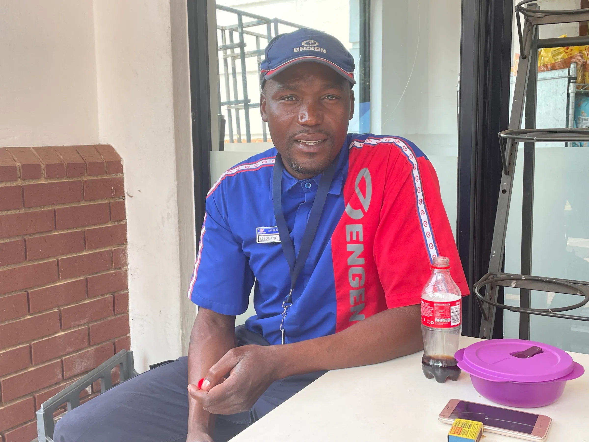 Petrol attendant Lebogang Ramathoka poses for a photo during his shift break at a petrol station in Johannesburg, South Africa, October 7, 2022. Thomson Reuters Foundation/Kim Harrisberg