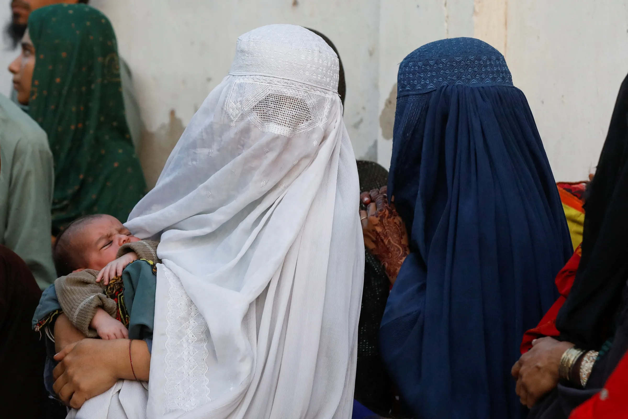 Afghan women queue to board a bus to return home, after Pakistan gave last warning to undocumented migrants to leave, at a bus stop in Karachi, Pakistan October 29, 2023. REUTERS/Akhtar Soomro