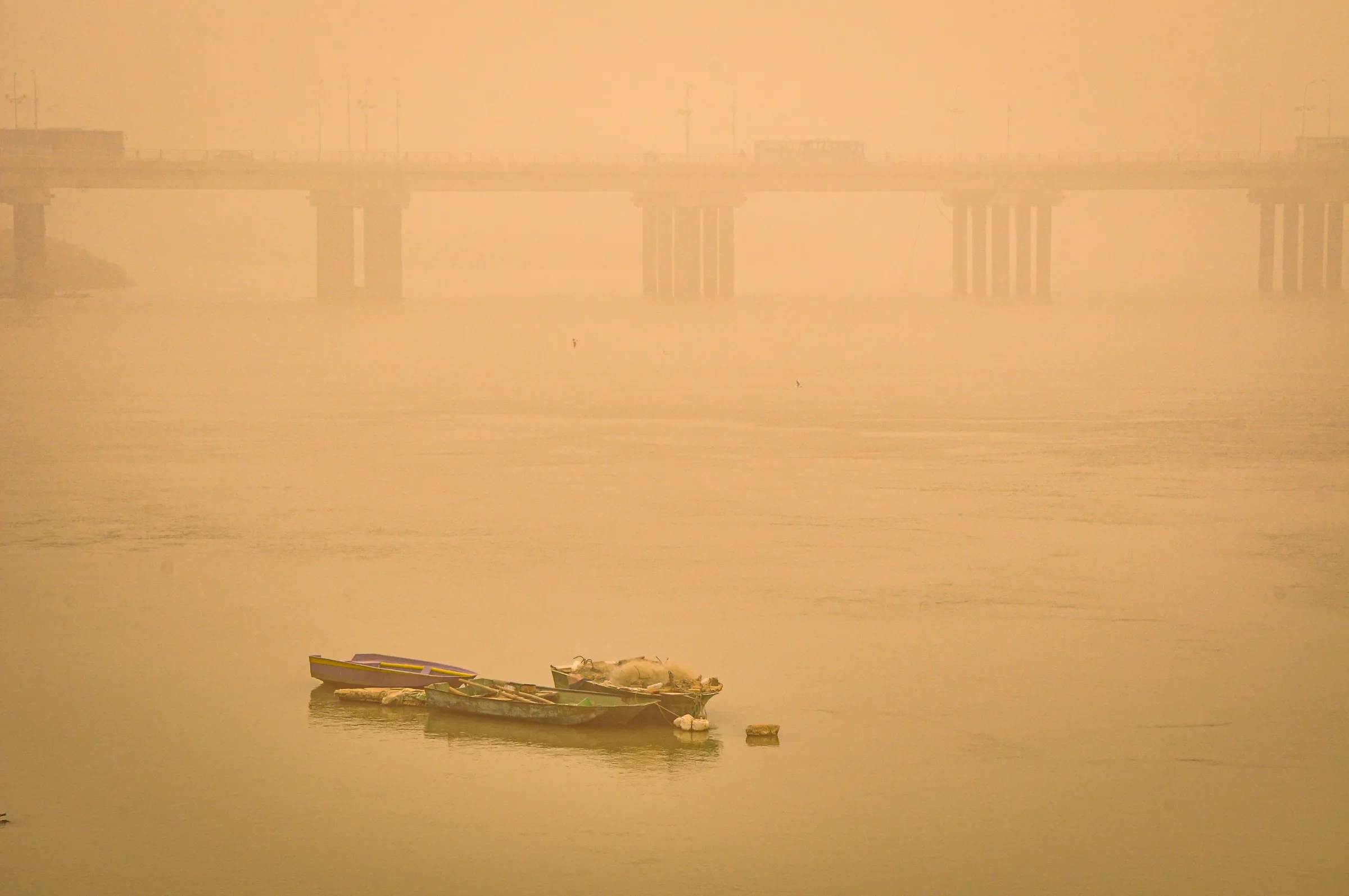 Boats on the Karun river blanketed in a thick haze during one of the increasingly frequent and intense sand and dust storms hitting the Middle East