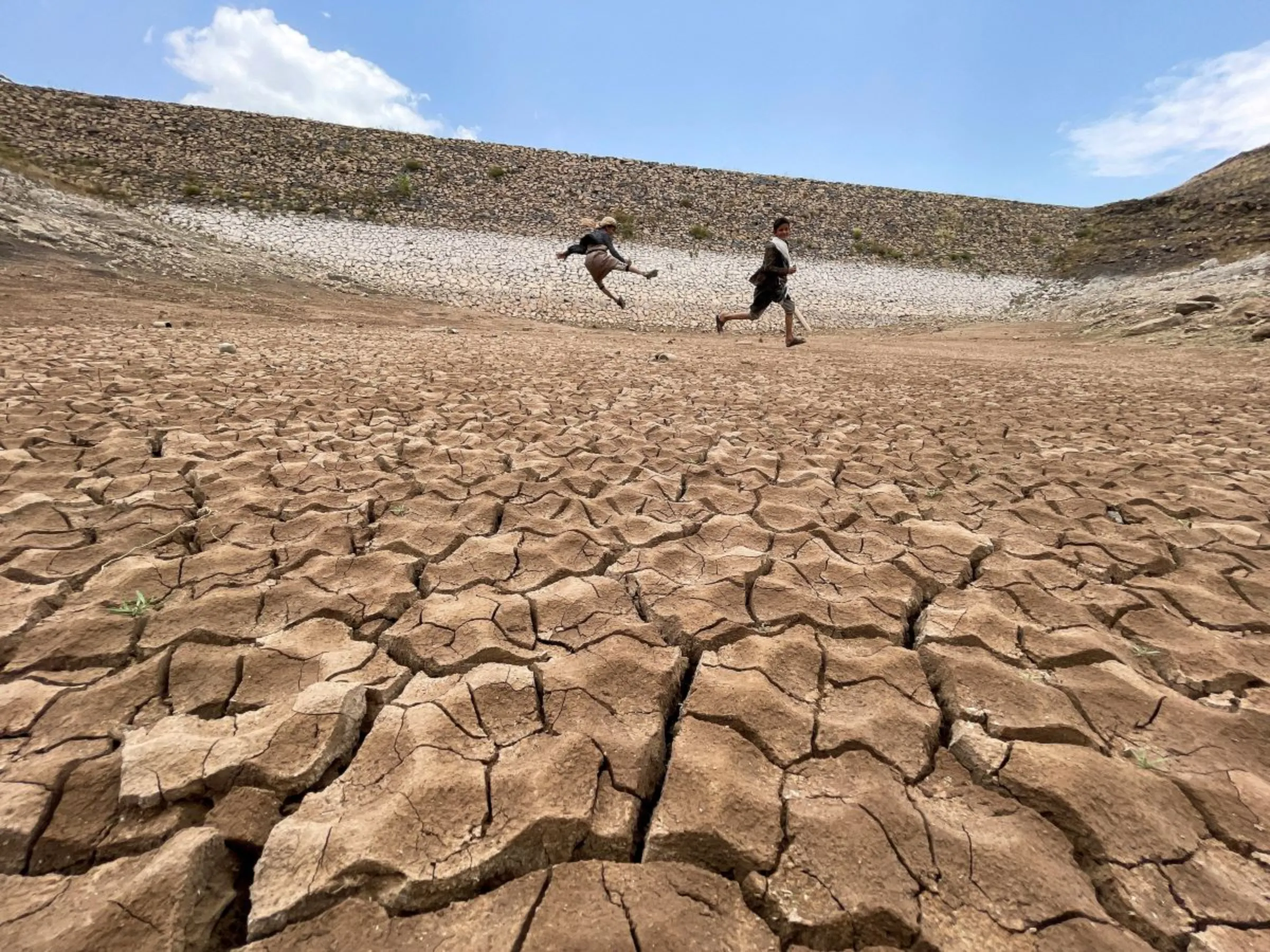 Boys play in a dried up dam in Khawlan, Yemen, August 31, 2023. REUTERS/Khaled Abdullah