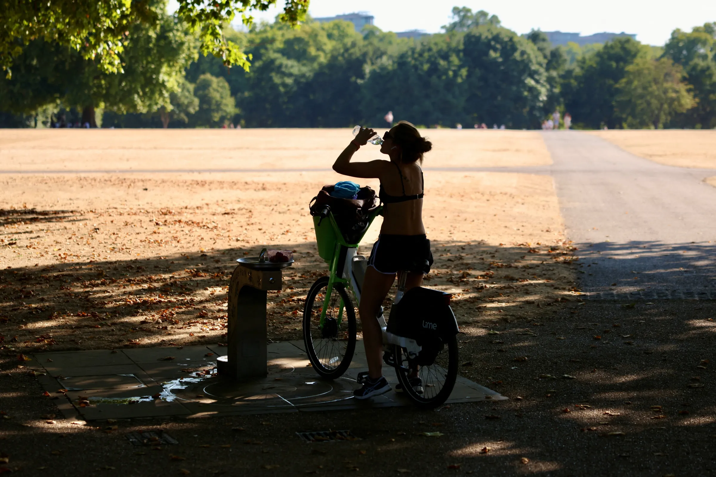 A cyclist stops at a drinking water fountain in Hyde Park during a heatwave in London