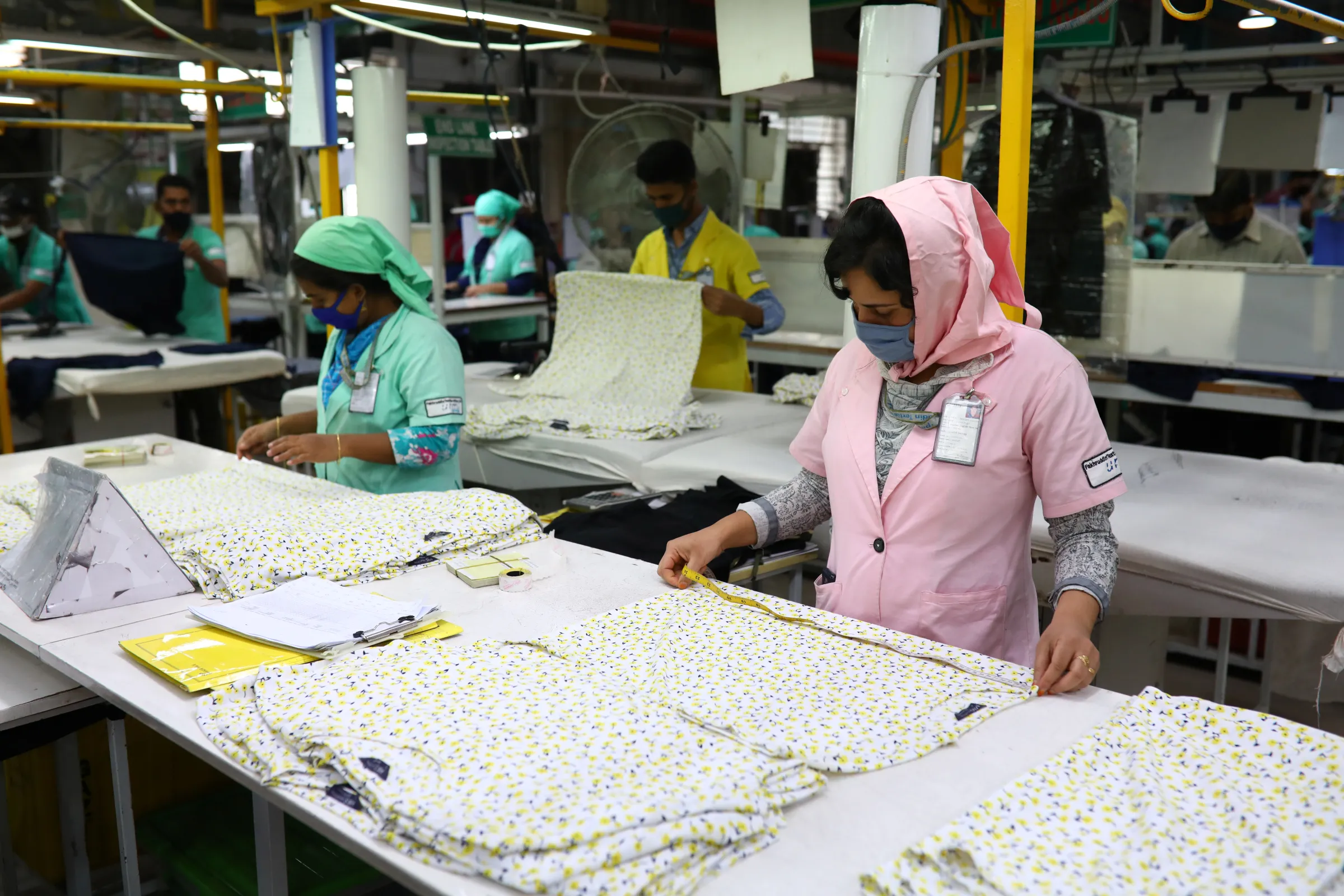 Garment workers check Marks and Spencer (M&S) t-shirts measurements at the Fakhruddin Textile Mills Limited in Gazipur, Bangladesh, February 7, 2021. REUTERS/Mohammad Ponir Hossain