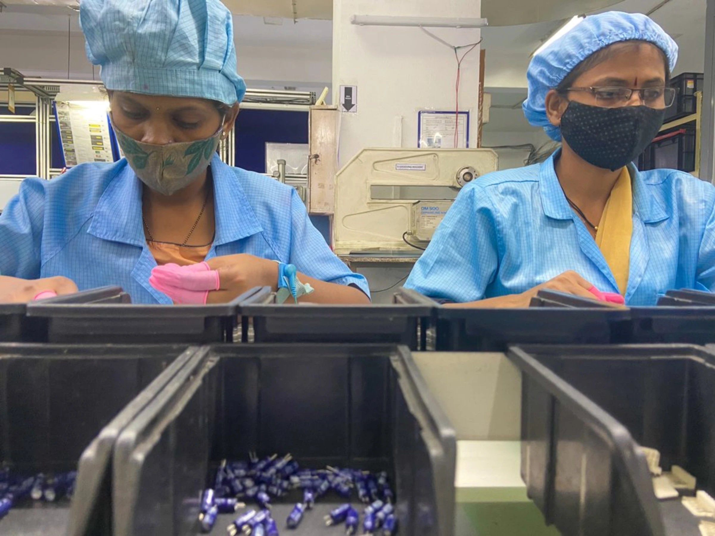 Workers assemble circuits on the Kinetic Communications factory floor in Pune, India, April 20, 2022