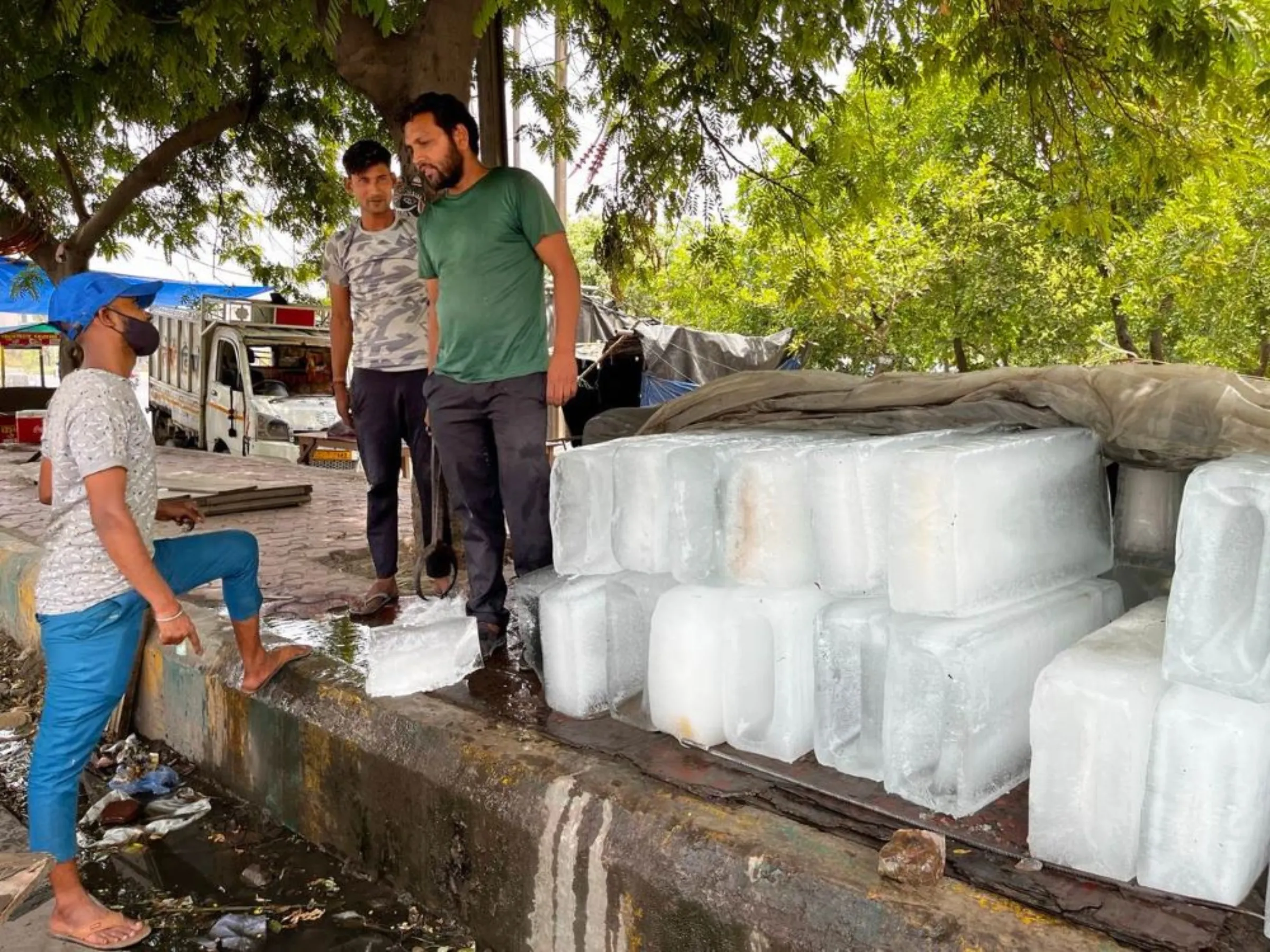 A customer chats with an ice vendor during an intense heatwave in Noida, India, May 18, 2022