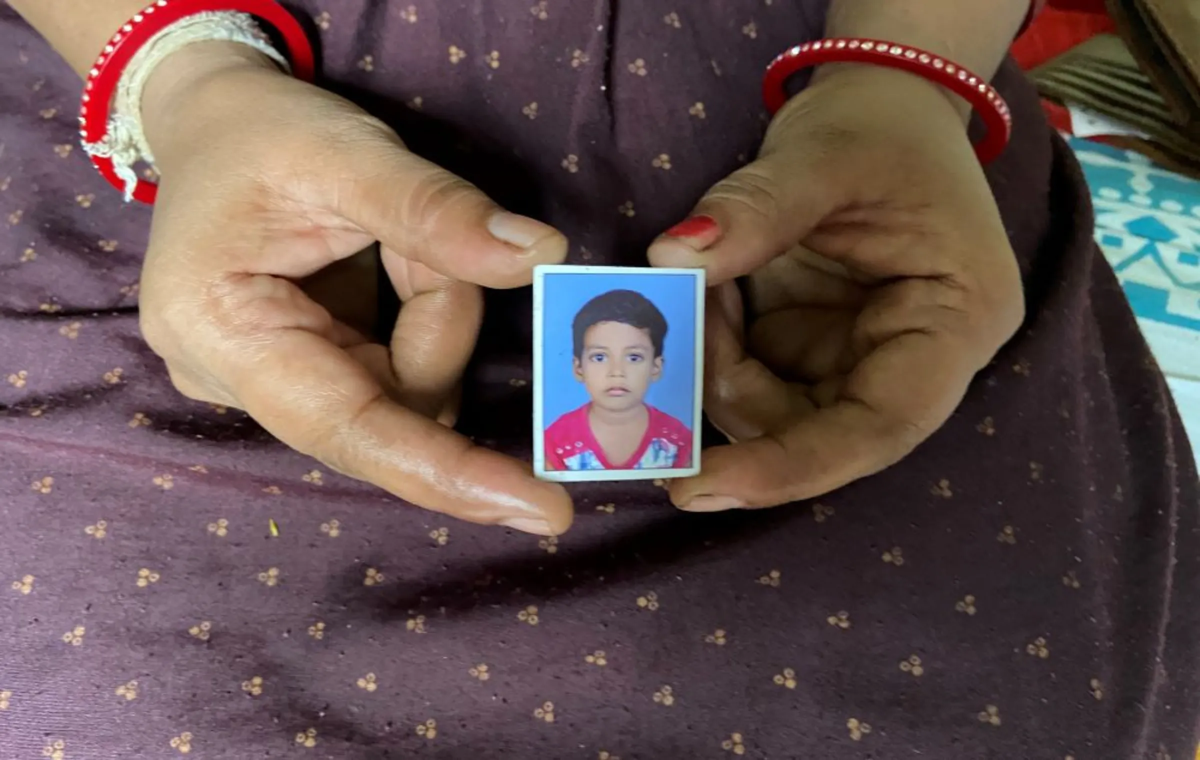 Nisha Umashankar Dandekar shows the picture of her five-year-old daughter who died in a leopard attack last year in Chandrapur, India, August 19, 2021. Thomson Reuters Foundation/Roli Srivastava