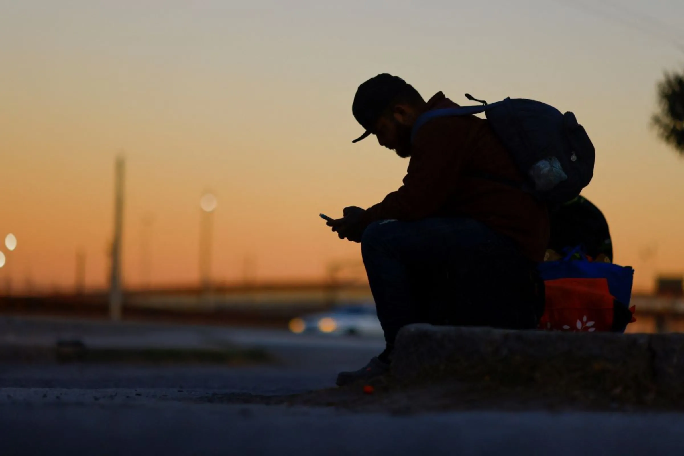 A migrant seeking asylum in the U.S. uses his phone to request an appointment at a land port of entry to the U.S., in Ciudad Juarez, Mexico January 12, 2023. REUTERS/Jose Luis Gonzalez