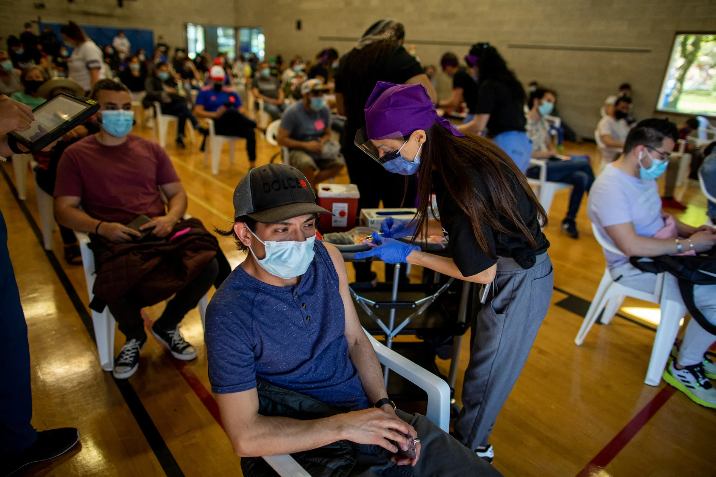Doctor administers COVID-19 vaccine at a clinic organized by the Latino community, an ethno-racial group more at risk of hospitalization from coronavirus disease, in Toronto, Canada May 14, 2021. REUTERS/Carlos Osorio