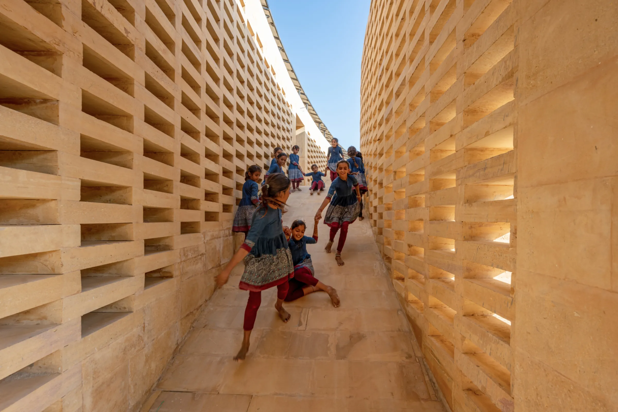 Girls play in a shaded passage at the Rajkumari Ratnavati Girls School in Rajasthan, northwest India, designed by New York architect Diana Kellogg. Photo taken 2021 by Vinay Panjwani. Diana Kellogg Architects/Handout via Thomson Reuters Foundation