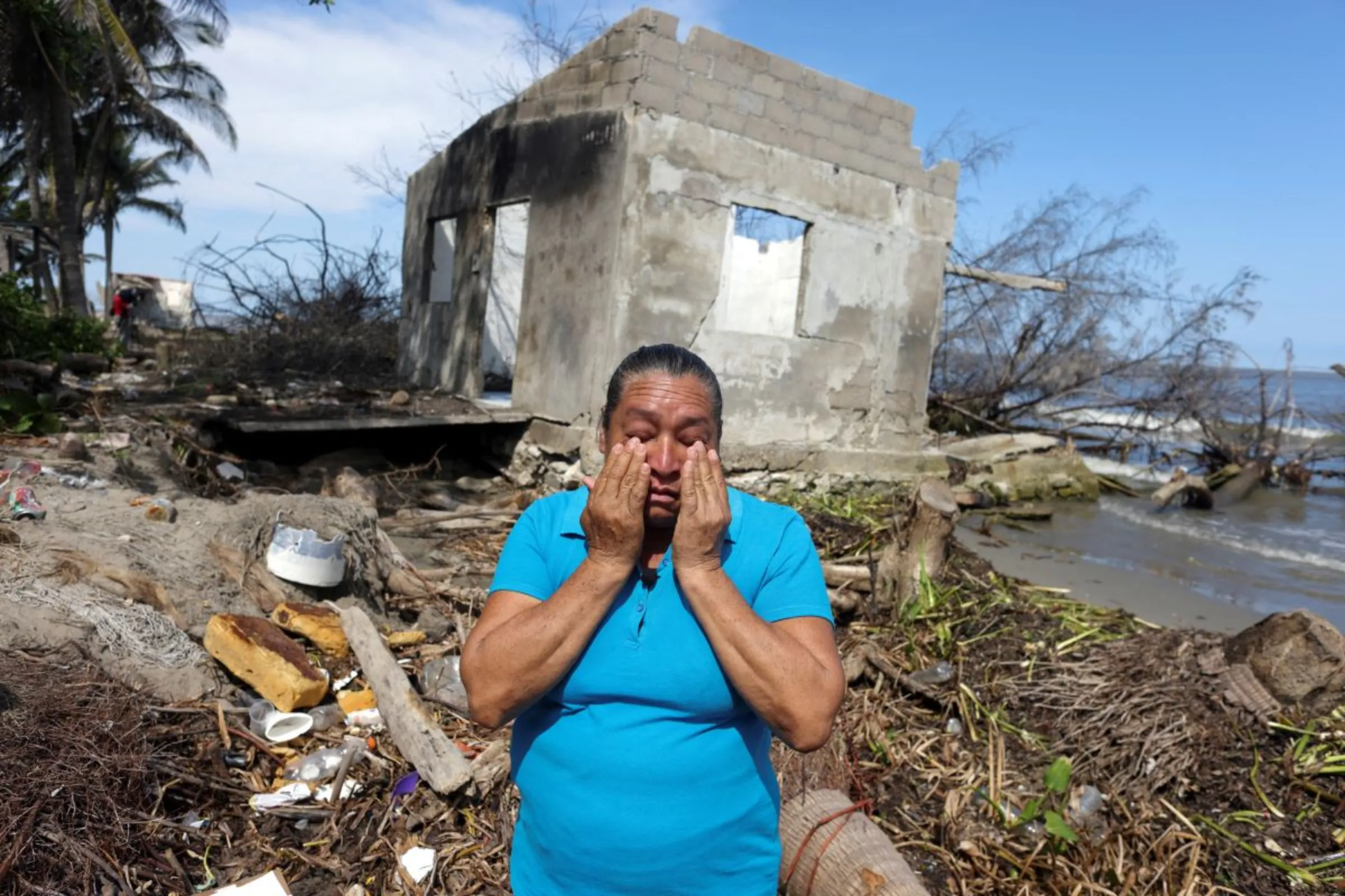 A resident of El Bosque cries in front of what is left of her house as rising sea levels are destroying homes built on the shoreline and forcing villagers to relocate, in El Bosque, Mexico November 7, 2022. REUTERS/Gustavo Graf