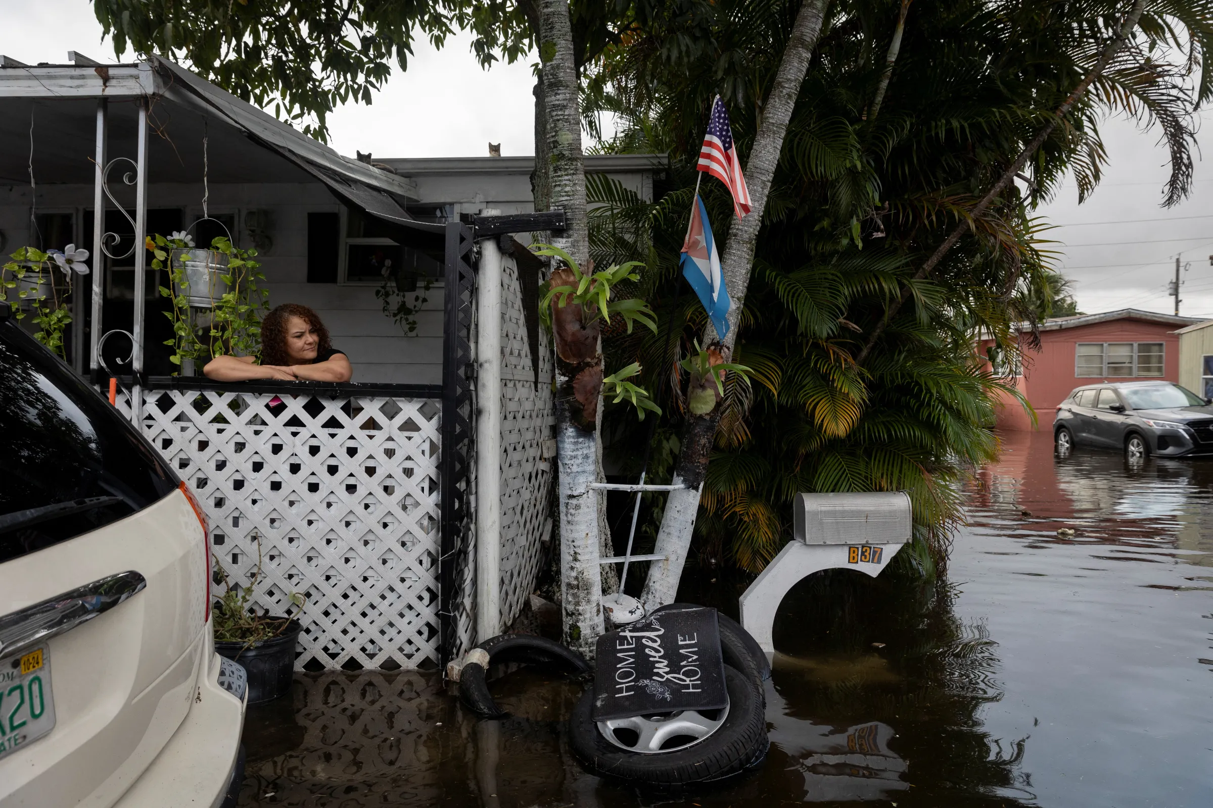 A woman looks at flood water from her house at a trailer park community in Hialeah, Florida, U.S., November 16, 2023. REUTERS/Marco Bello