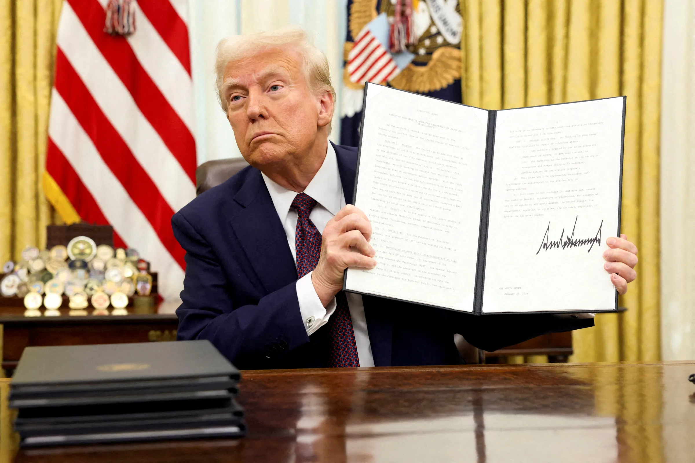 U.S. President Donald Trump holds a signed executive order on AI, in the Oval Office of the White House, in Washington, U.S., January 23, 2025. REUTERS/Kevin Lamarque