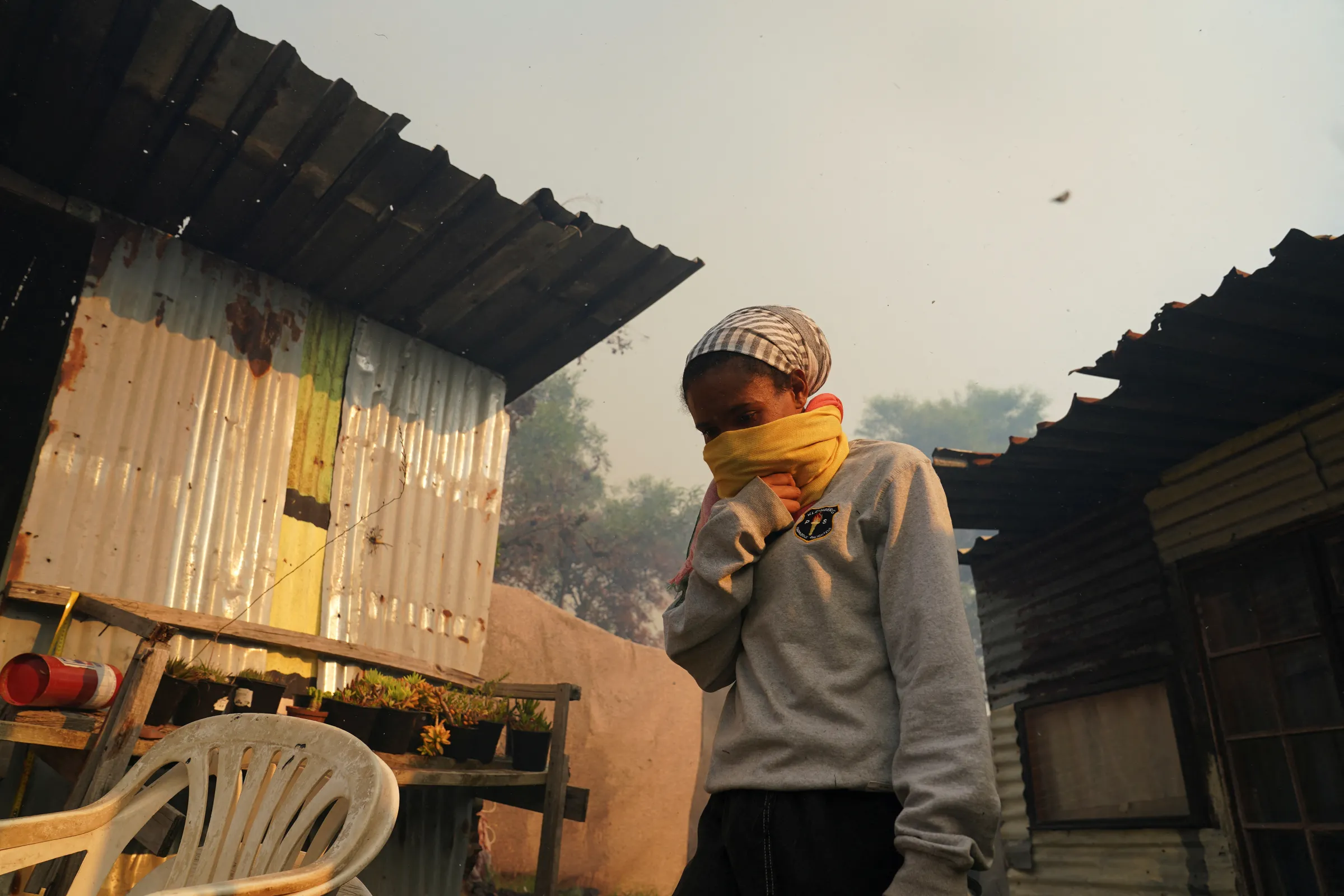 A resident covers her mouth and nose amid thick smoke from a mountain fire in Ocean View, Cape Town, South Africa January 22, 2024. REUTERS/Nic Bothma