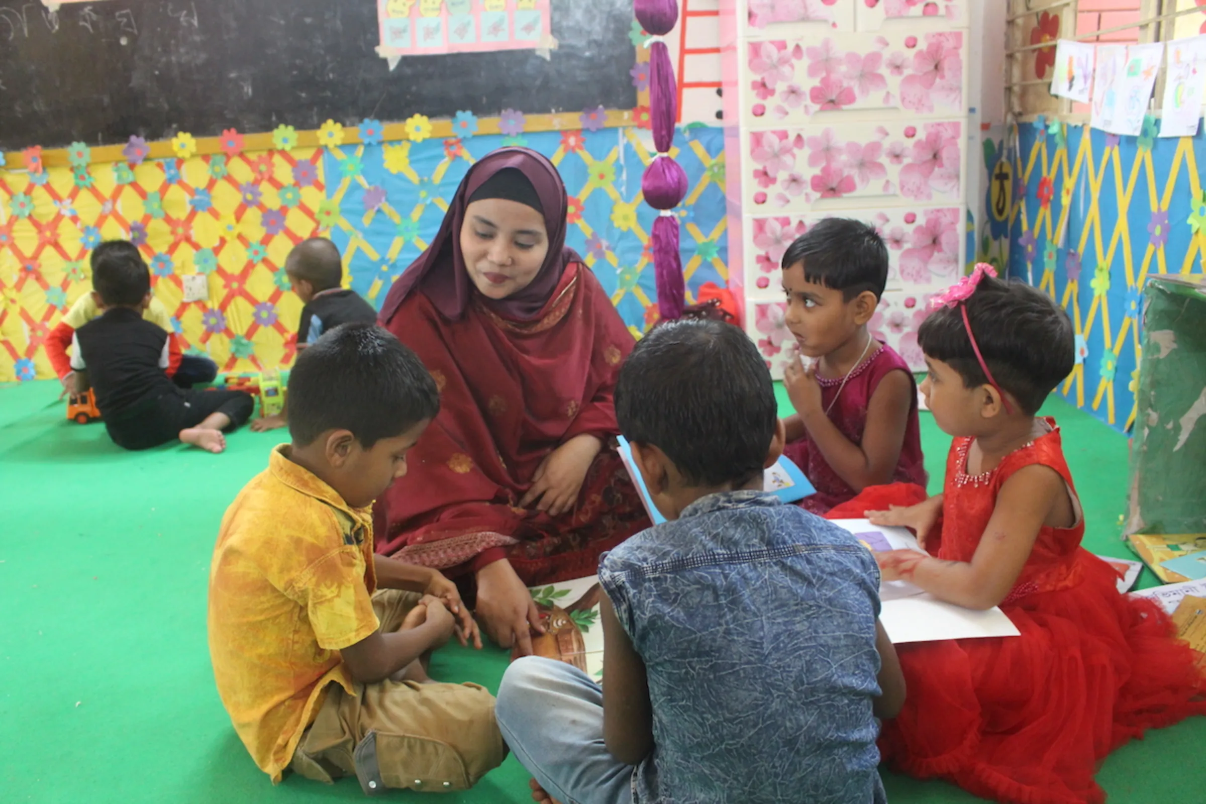 Children aged between three and five listen to a teacher at a green play lab supported by development organisation BRAC at Brahmangaon, Gazipur, Bangladesh, November 11, 2023
