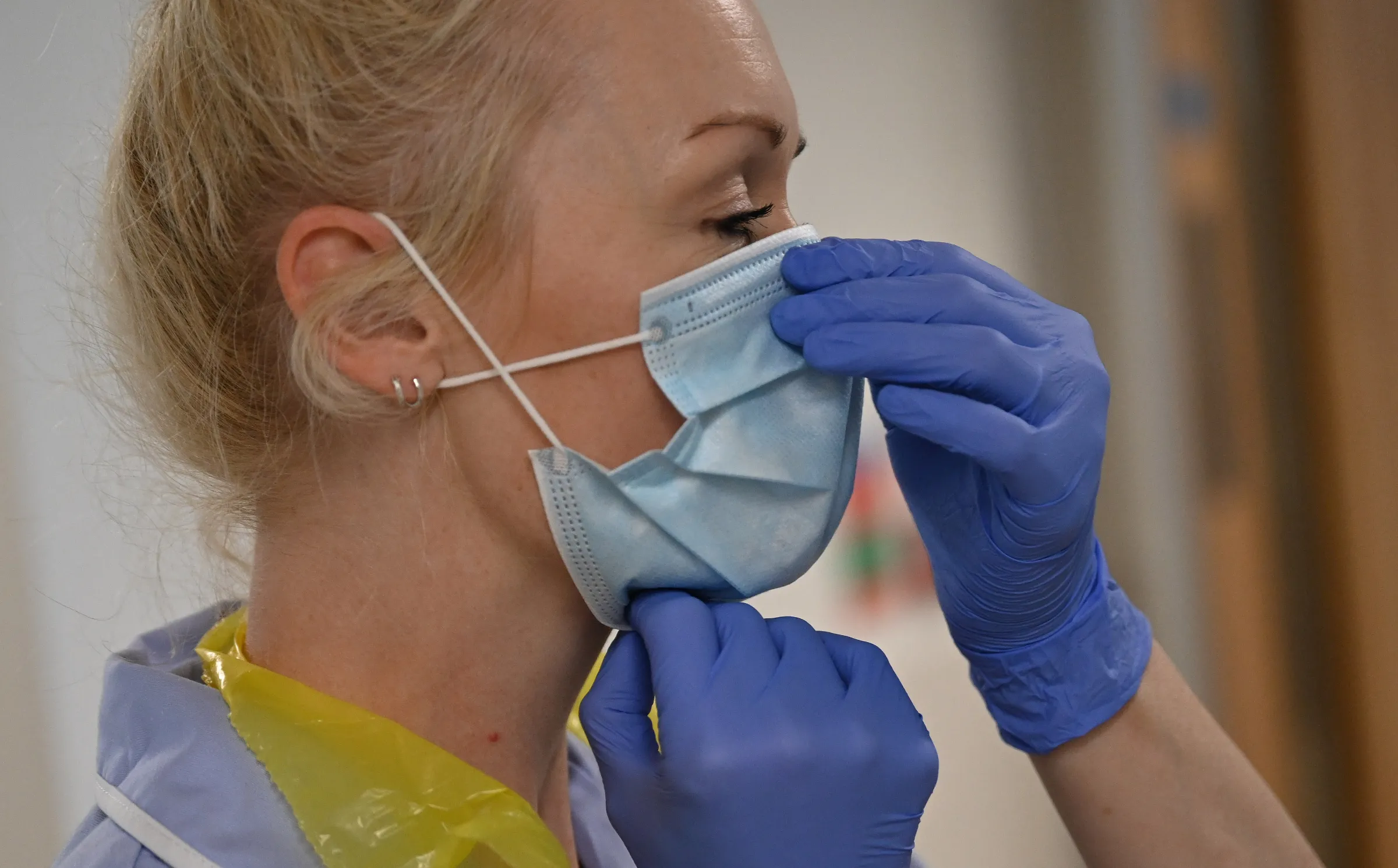 A health worker adjusts her mask as she cares for patients during the COVID pandemic in Cambridge, Britain May 5, 2020. Neil Hall/Pool via REUTERS