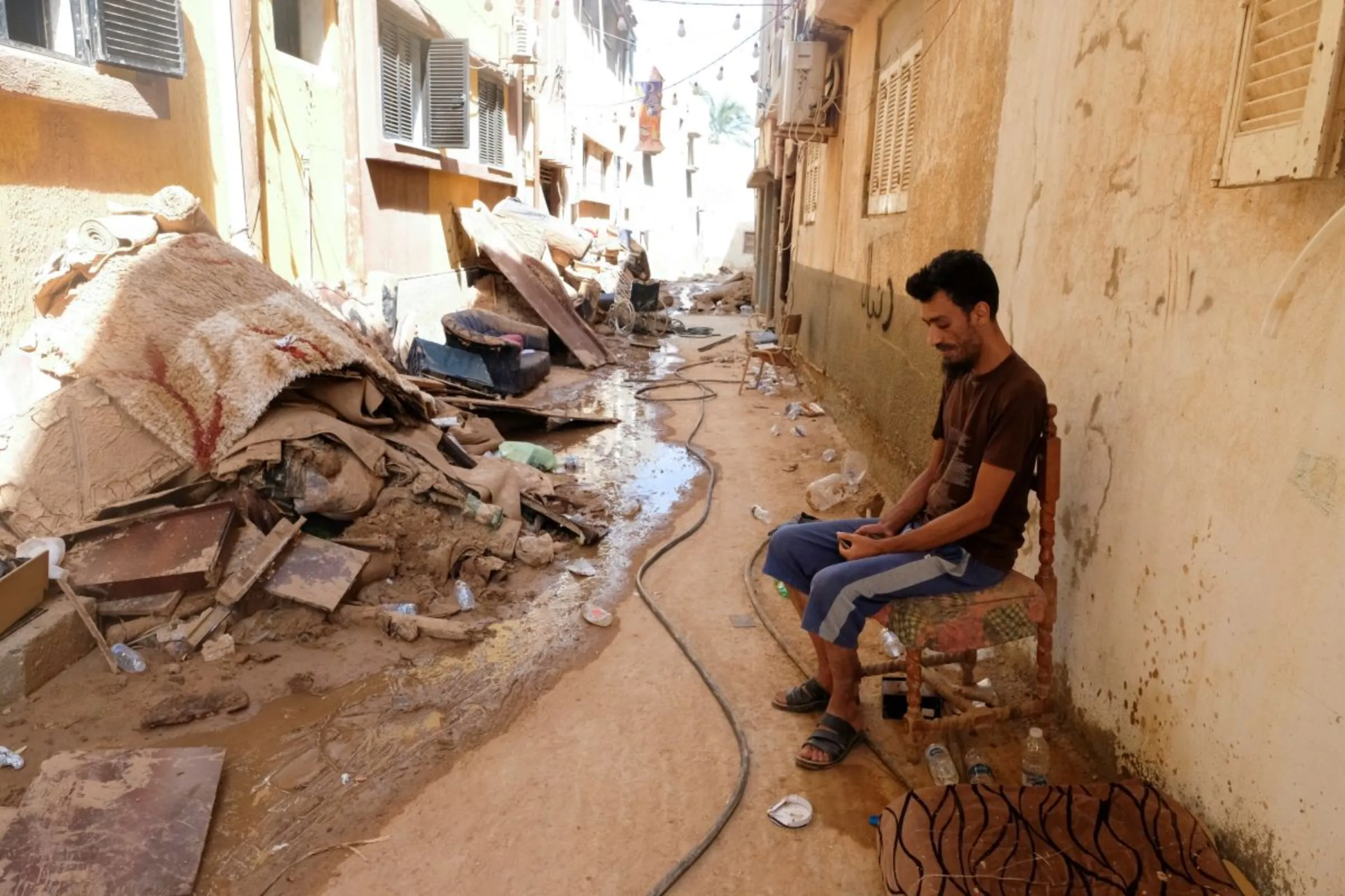 A man sits in front of his house that was impacted by fatal floods in Derna, Libya, September 28, 2023