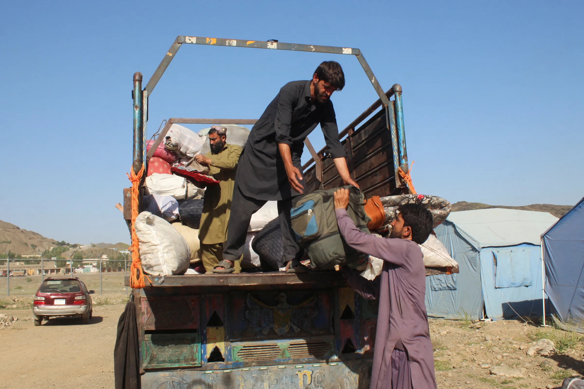 Afghan men, who were expelled from Pakistan, unload their belongings from a truck upon their arrival at the Omari refugee camp, in Mohmand Dara, Torkham border, Nangarhar province Afghanistan, April 15, 2025. REUTERS/Hedyatshah Hedayat