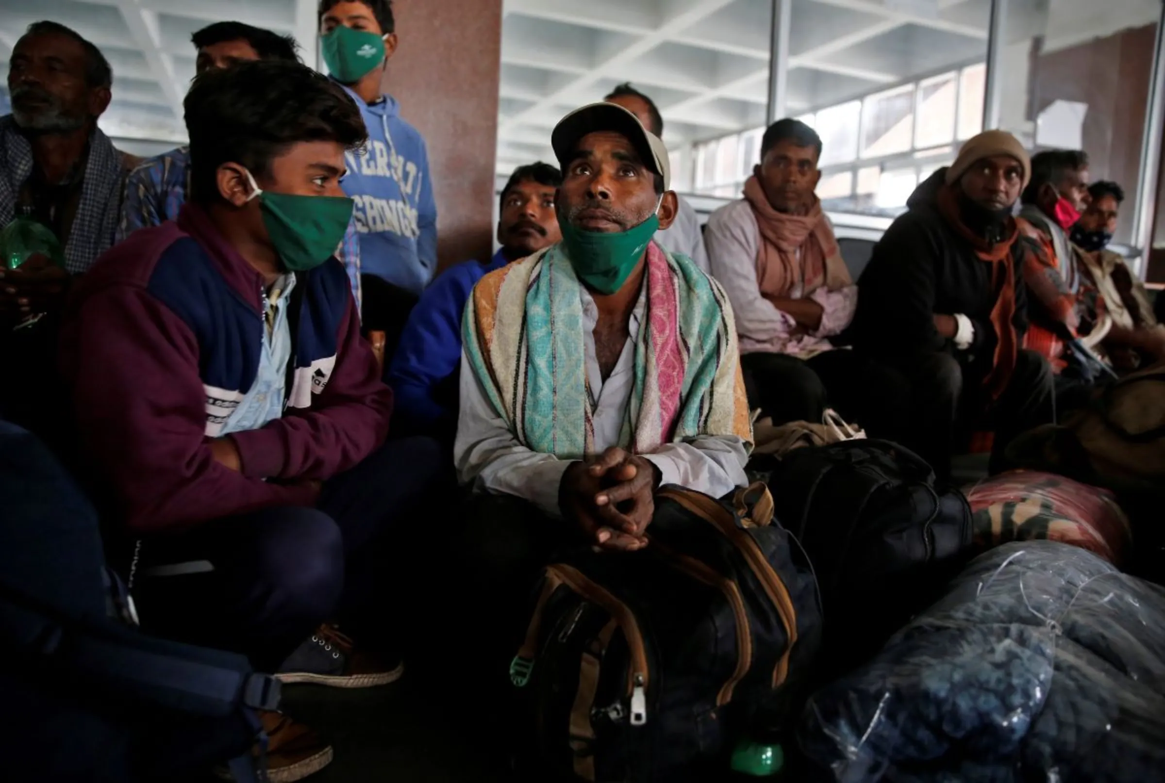 Indian migrant workers wait inside a railway station to board trains to their home states following attacks on migrant labourers by suspected militants in Kashmir, on the outskirts of Srinagar October 18, 2021. REUTERS/Danish Ismail