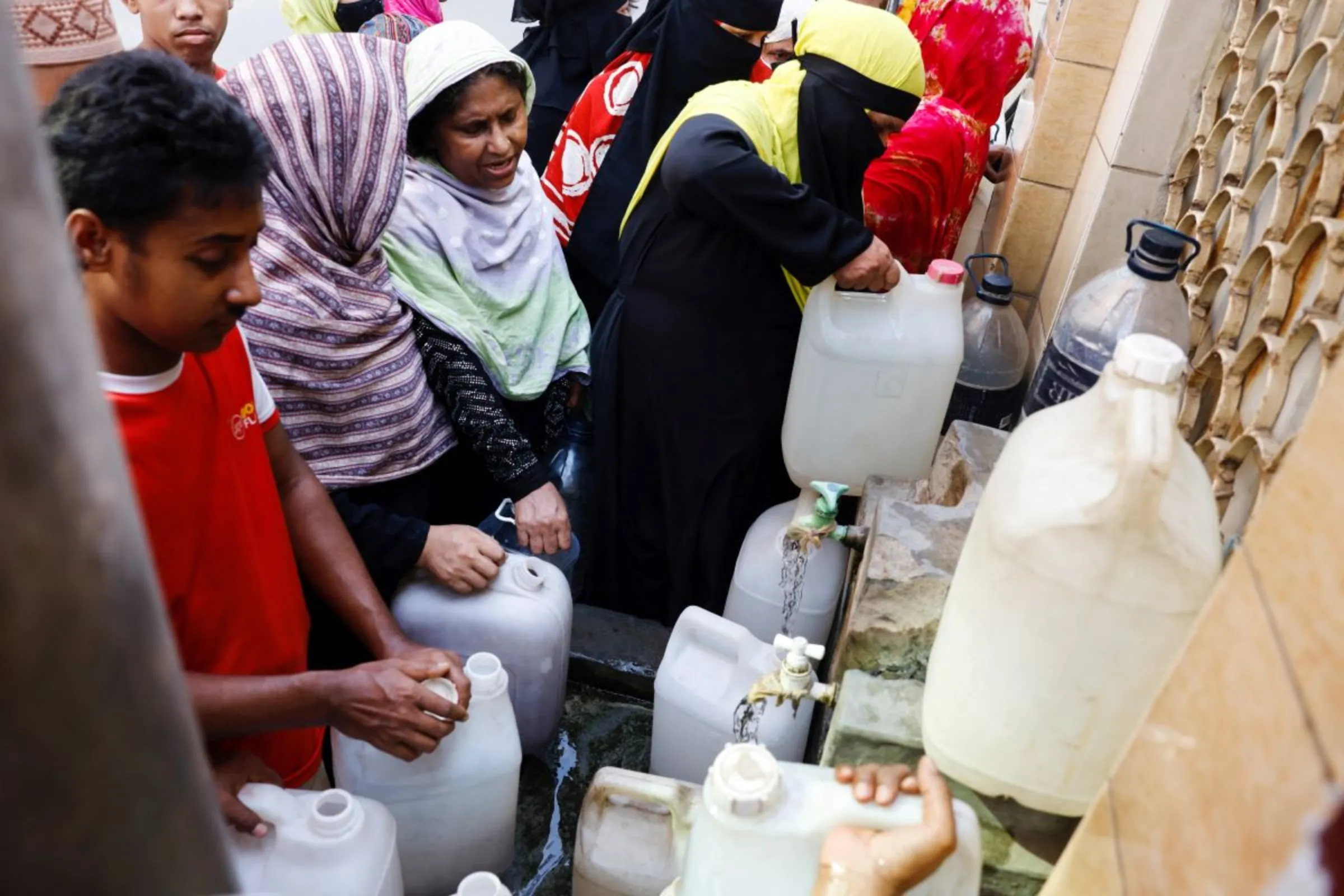 People collect drinking water from a roadside tap during a countrywide heatwave, in Dhaka, Bangladesh, June 6, 2023.REUTERS/Mohammad Ponir Hossain