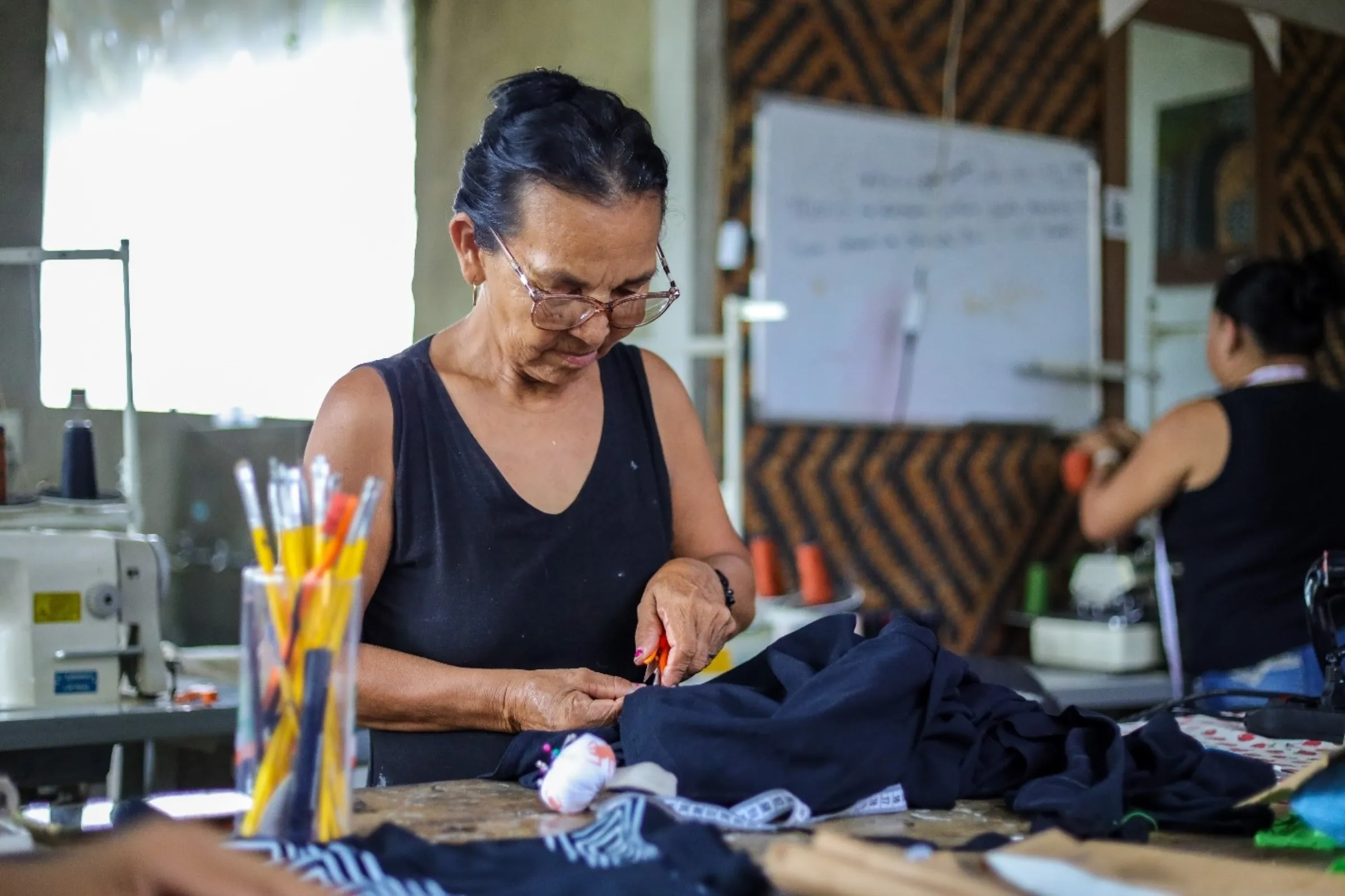 Leia Witoto cuts fabric in Ateliê Derequine’s headquarters in Manaus, Brazil, March 12, 2025. Nathalie Brasil/Thomson Reuters Foundation