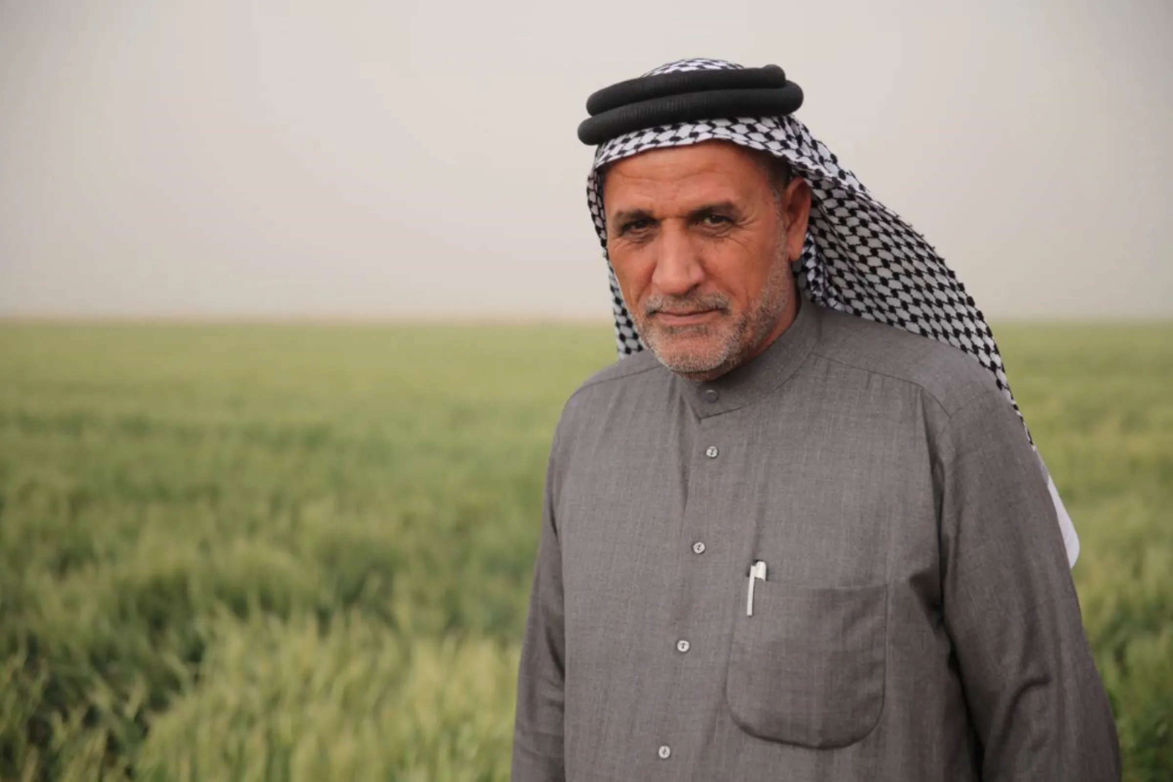 Wheat farmer Hadi Badr al Malaki stands in front of his wheat crop flattened by a sandstorm near the village of Al- Qurna in southern Iraq’s Basra governorate, March 7, 2022