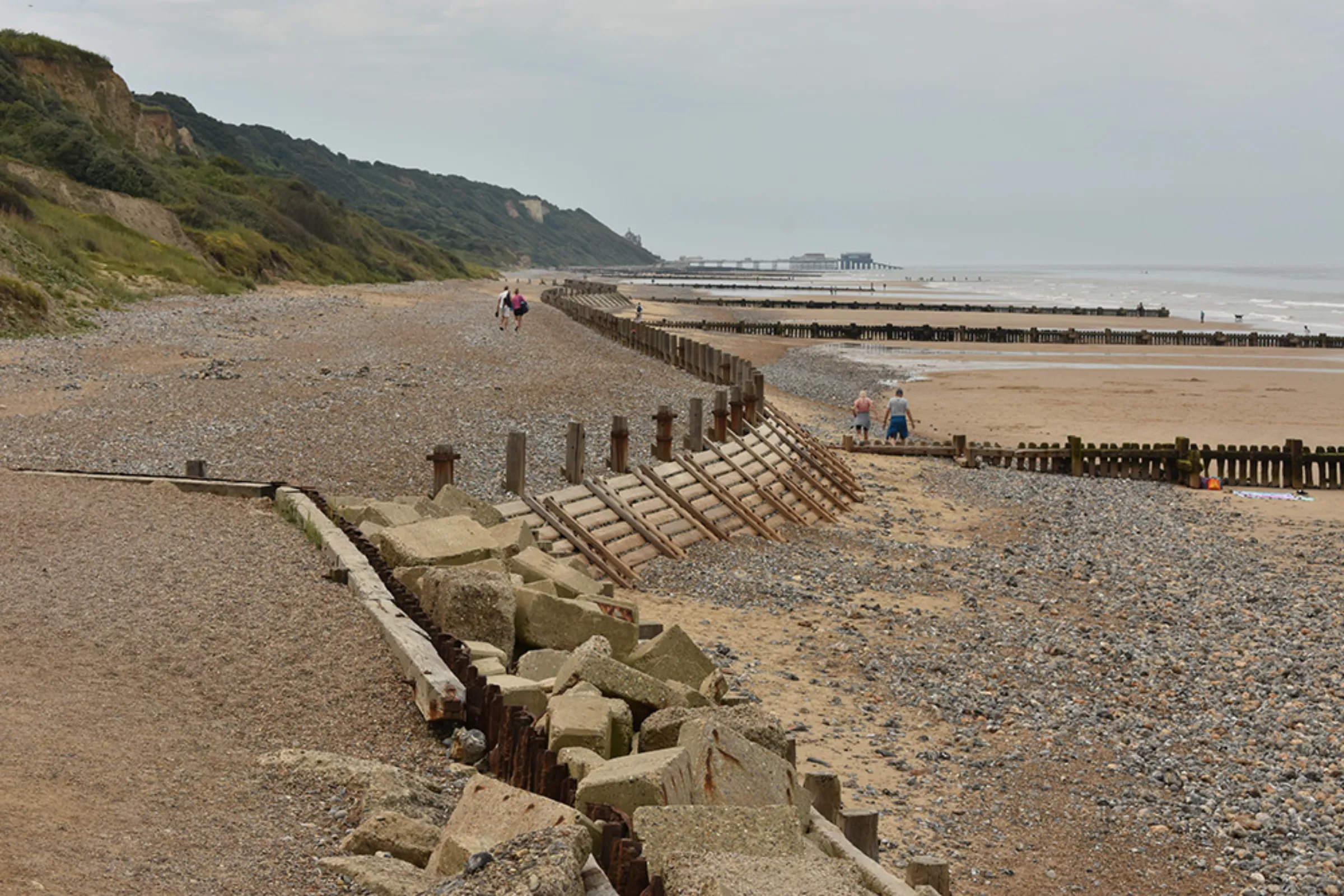 Riprap, a timber wave break, and wooden groynes protect the beach and trap sediment in Overstrand, England, June 17, 2023. Thomson Reuters Foundation/Rachel Parsons