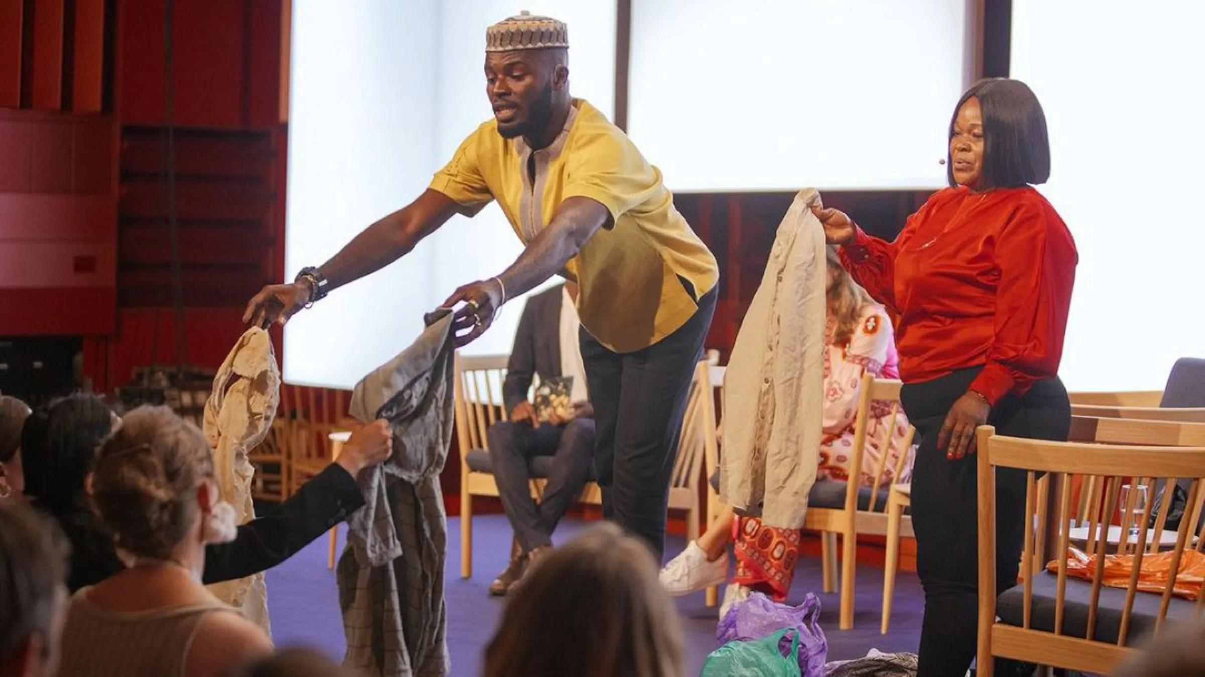 Sammy Oteng and Abena Essoun pass secondhand clothing from Accra’s beaches to the audience at the Global Fashion Summit in Copenhagen on June 27, 2023. Global Fashion Agenda/Global Fashion Summit 2023/Handout via Thomson Reuters Foundation