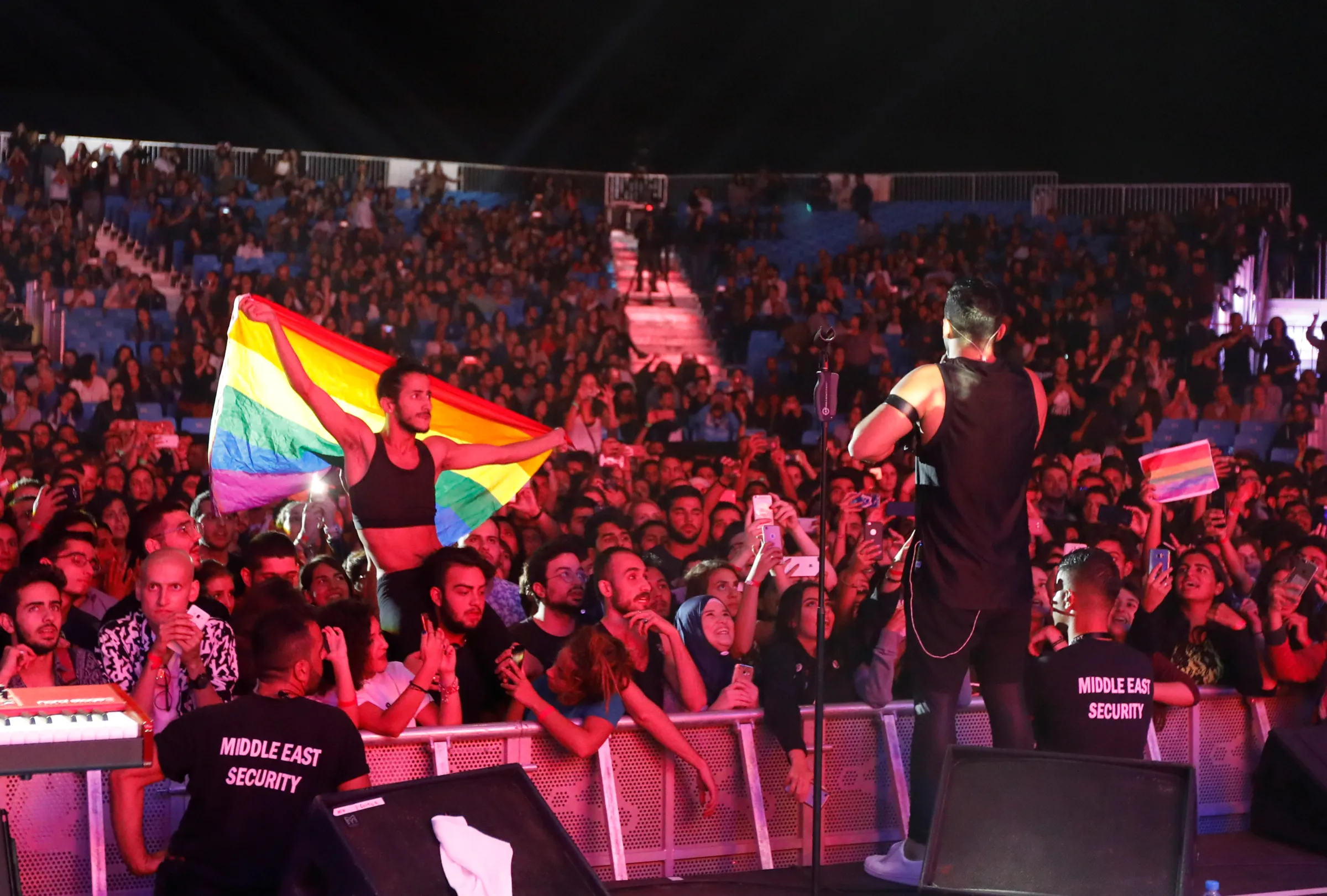 A fan of Lebanese alternative rock band Mashrou' Leila holds a rainbow flag during their concert at the Ehdeniyat International Festival in Ehden town, Lebanon August 12, 2017. REUTERS/Jamal Saidi