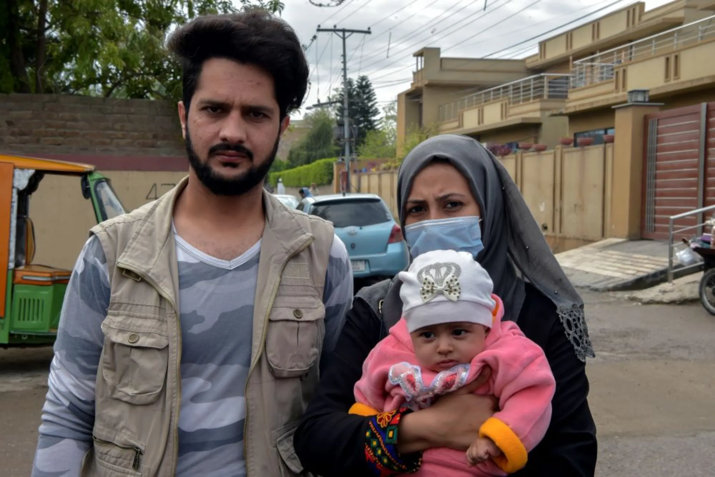 Afghan refugees, Samiullah Ahmadi and Lutfia Ahmadi, pose for a photo with their baby in Peshawar, Pakistan on March 8, 2022