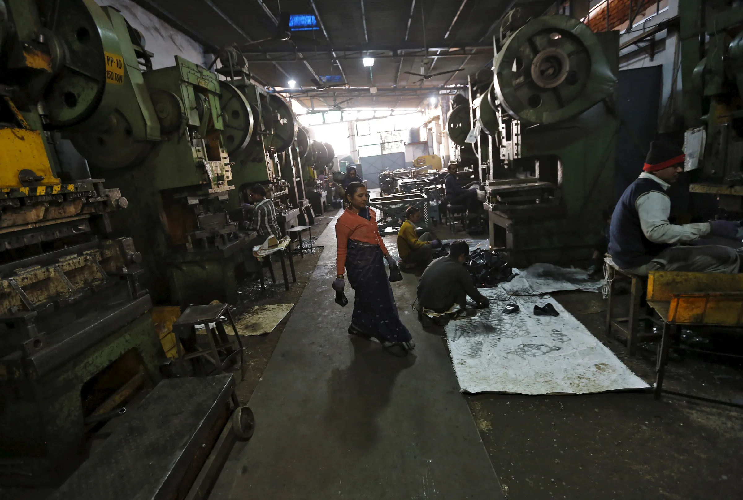 Workers make auto parts on machines inside a manufacturing unit in Faridabad, India, December 24, 2015. REUTERS/Adnan Abidi