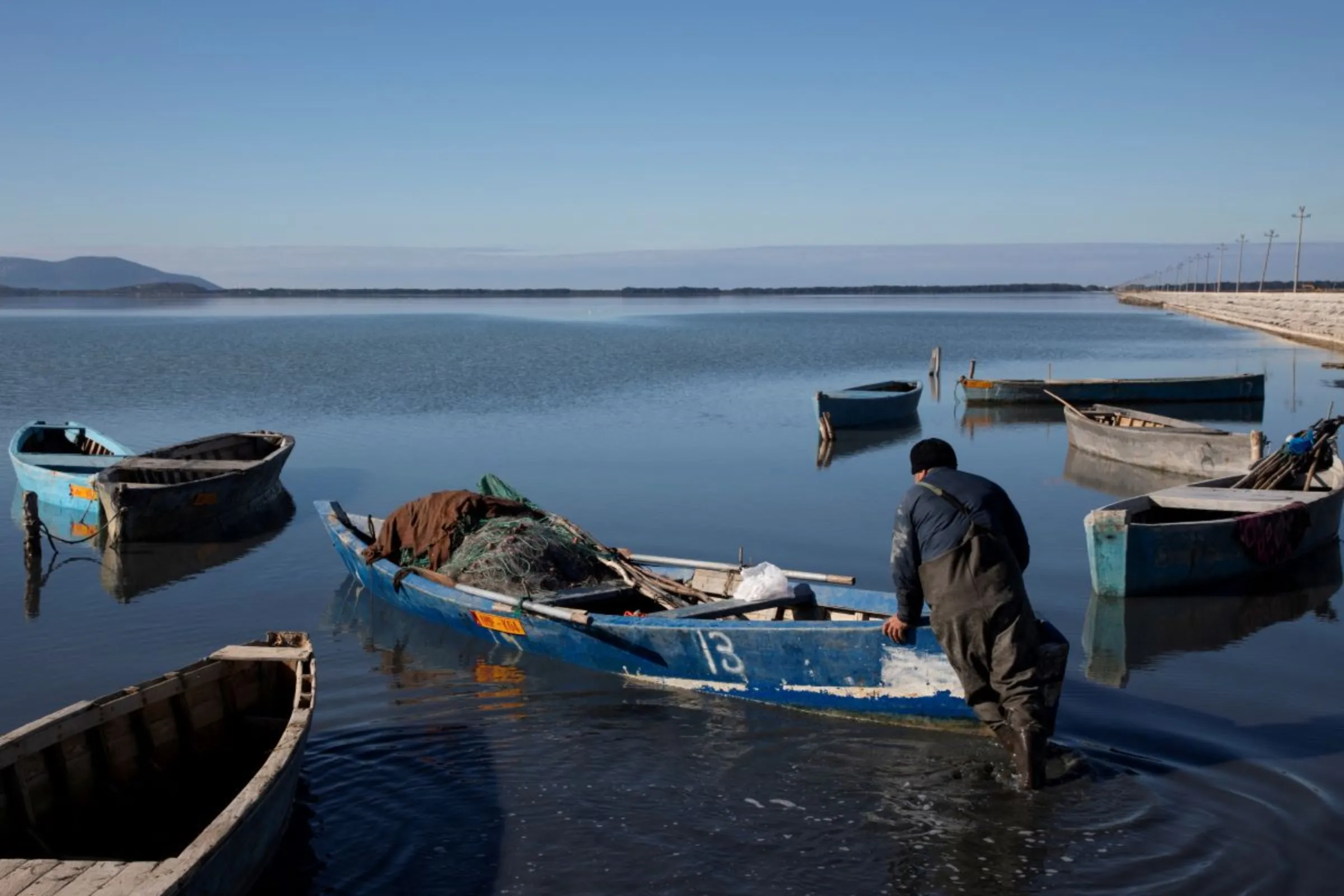 A fisherman pushes his boat at the Vjosa-Narte Protected area in Vlora, Albania, January 26, 2022