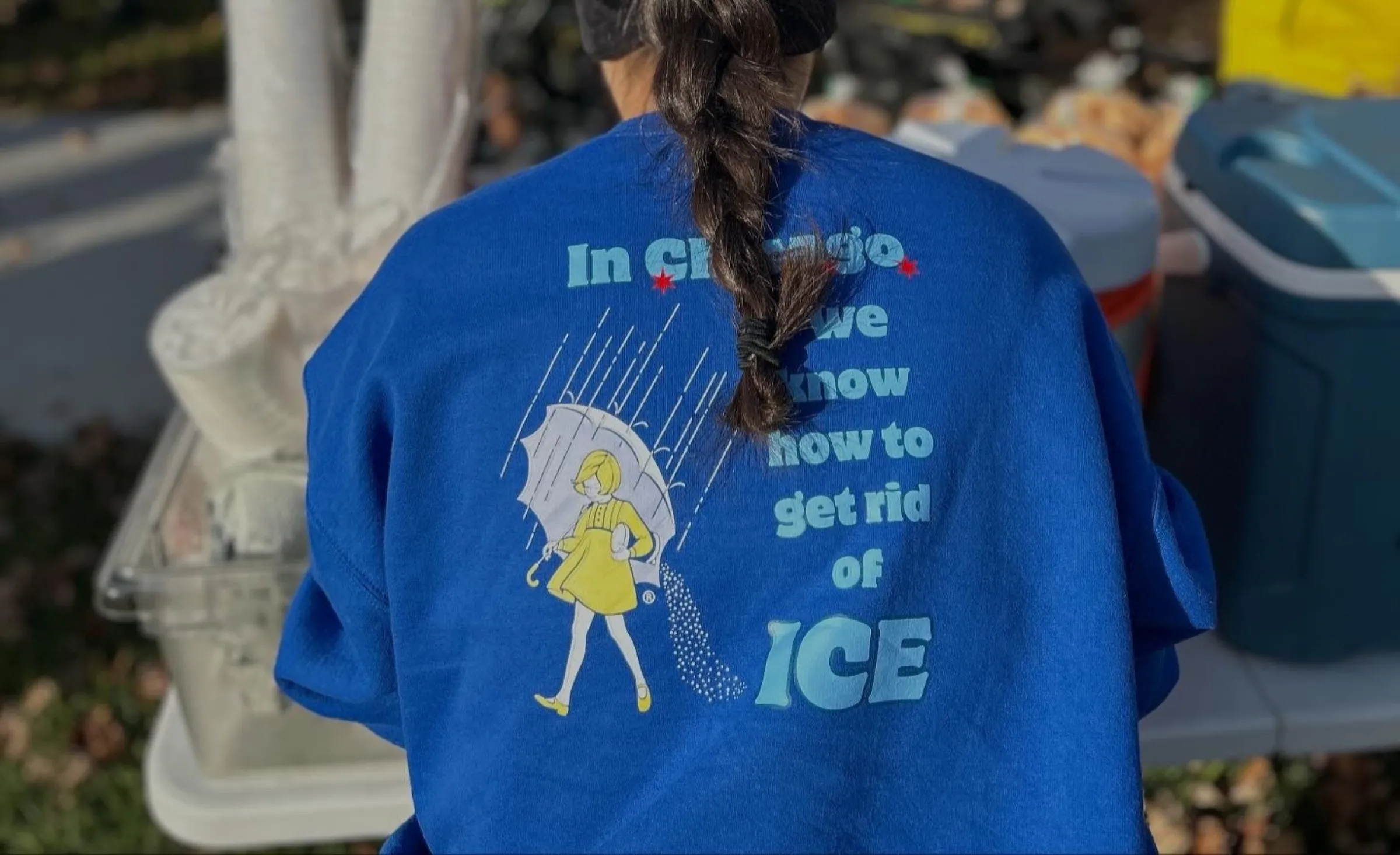 A woman's t-shirt reads 'In Chicago, we kow how to get rid of ICE' as bikers take part in an event to support street vendors in Chicago, United States on Nov. 2, 2025. @cyclingxsolidarity/Handout via Thomson Reuters Foundation