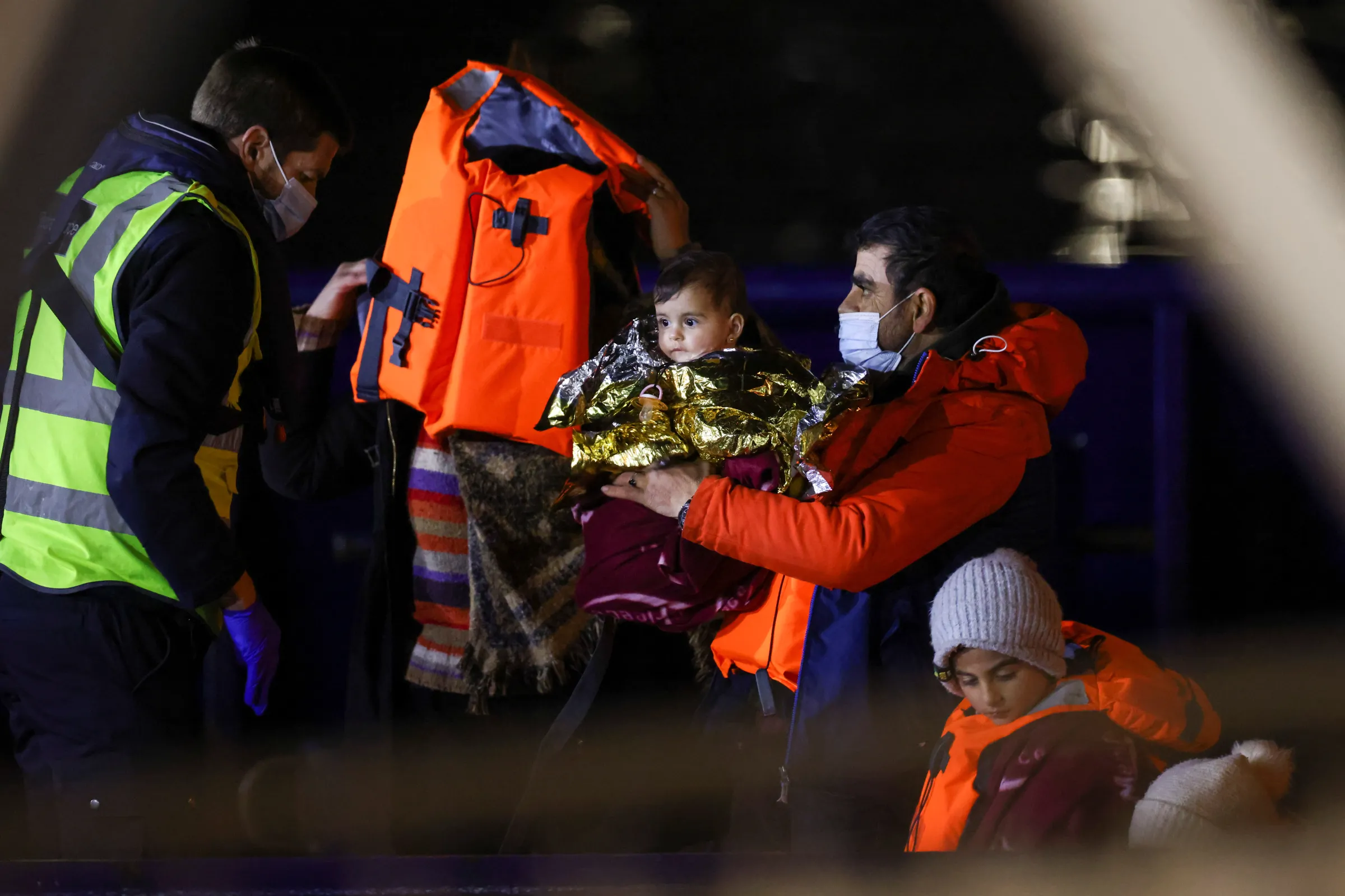 A migrant family arrives at the Port of Dover after being helped by Royal National Lifeboat Institution (RNLI), in Dover, Britain December 16, 2021