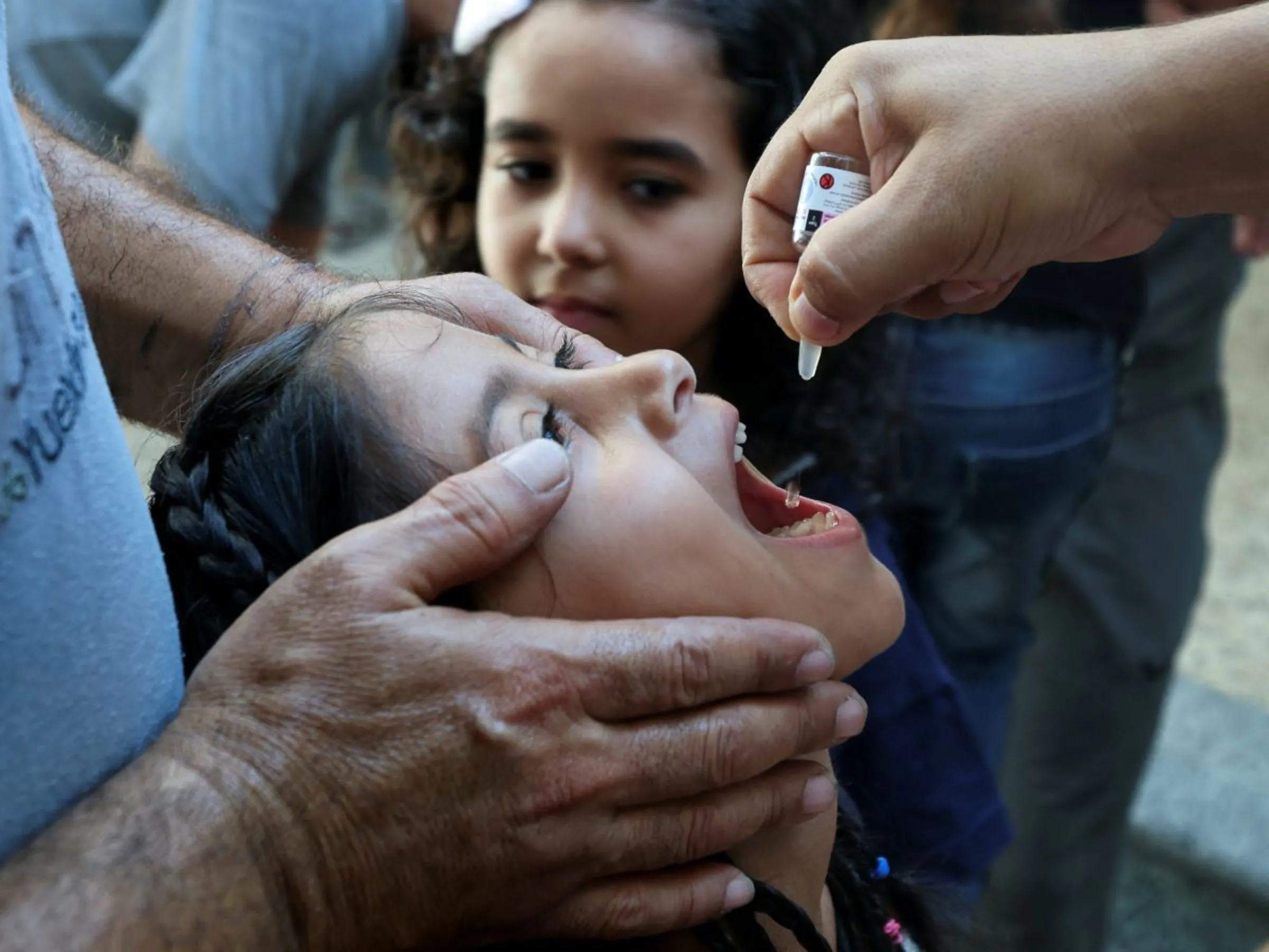 A Palestinian child is vaccinated against polio, amid the Israel-Hamas conflict, in Deir Al-Balah in the central Gaza Strip, September 4, 2024. REUTERS/Ramadan Abed