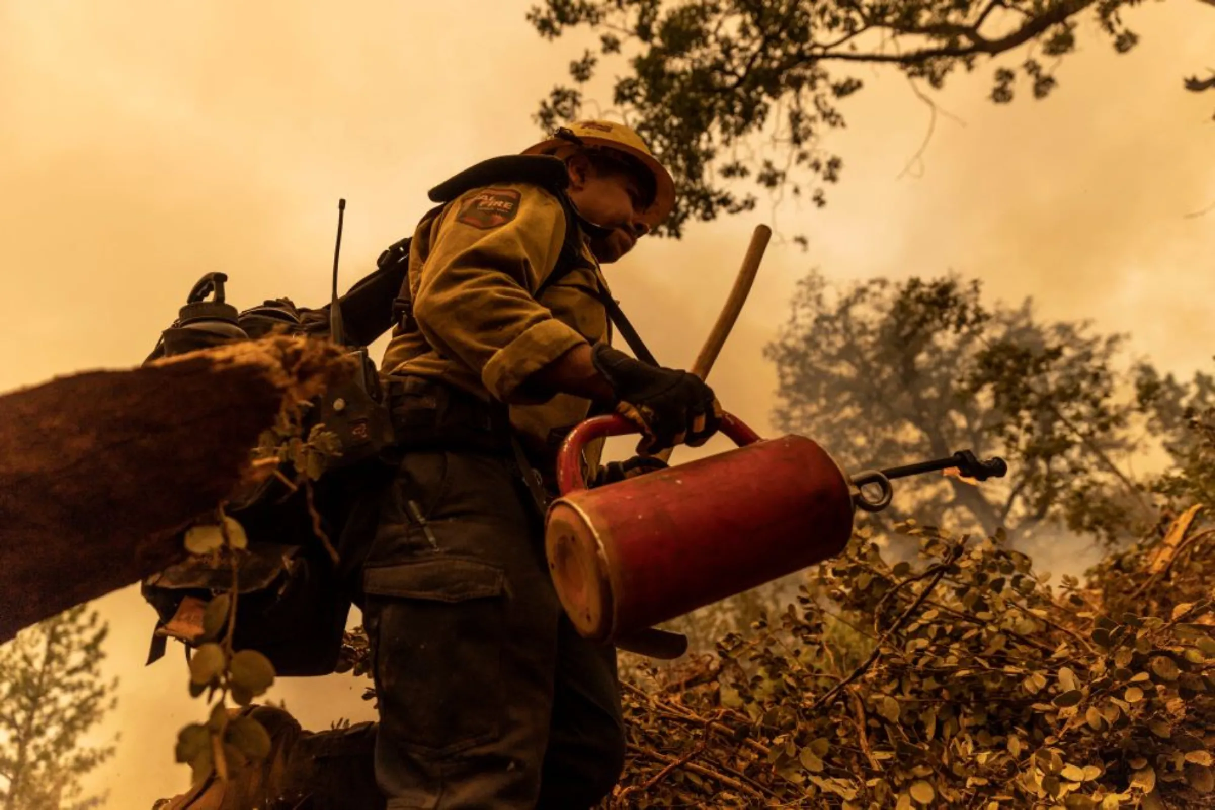 A firefighters works to extinguish the Oak Fire as it burns near Darrah in Mariposa County, California, U.S., July 24, 2022