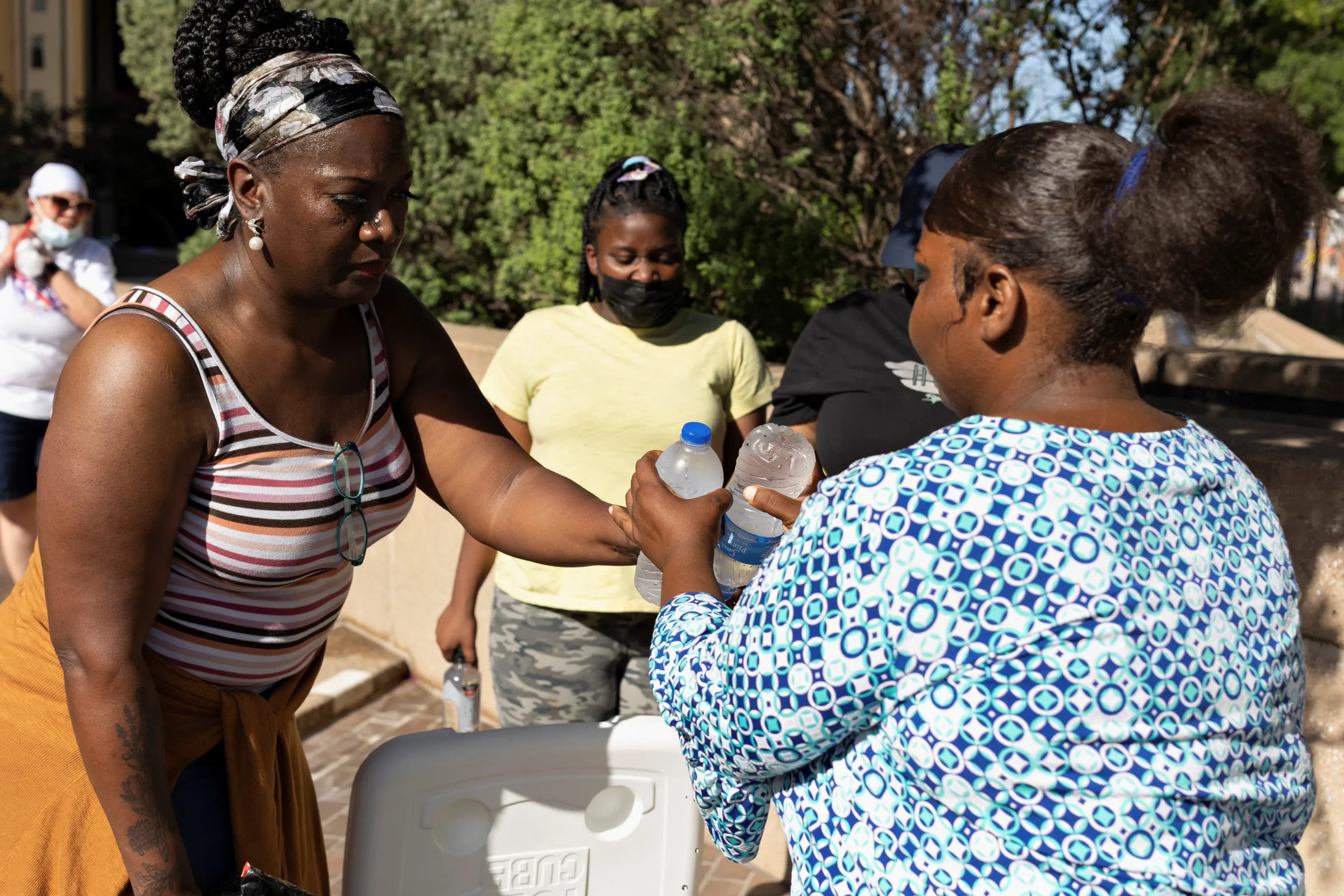 A volunteer passes out cold water bottles during a heatwave with expected temperatures of 102 F (39 C) in Dallas, Texas, U.S. June 12, 2022. REUTERS/Shelby Tauber