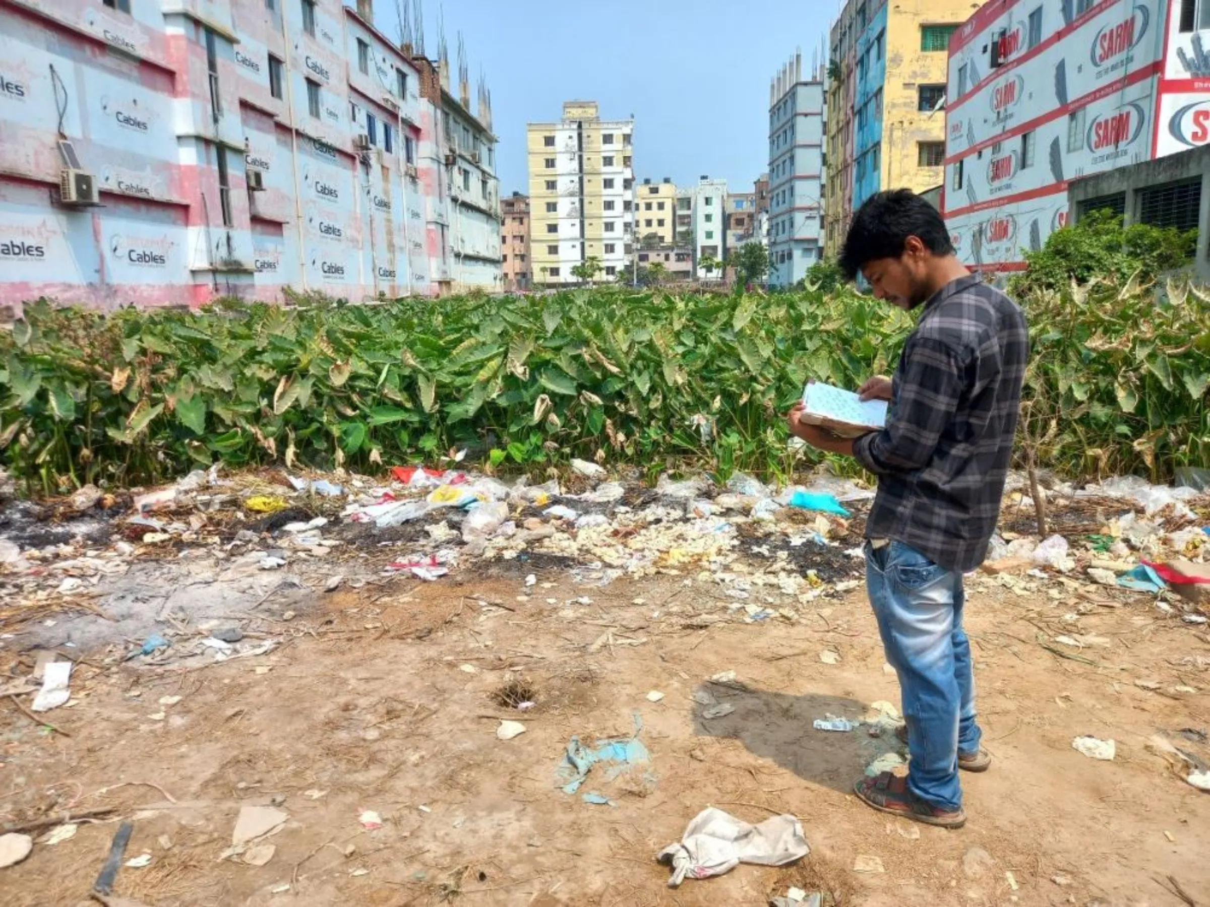Rajib Das stands before the Rana Plaza site reminiscing how his family waited for and finally found the body of his brother Sanjit Das, who was killed in the incident, Savar, Bangladesh, April 17, 2023
