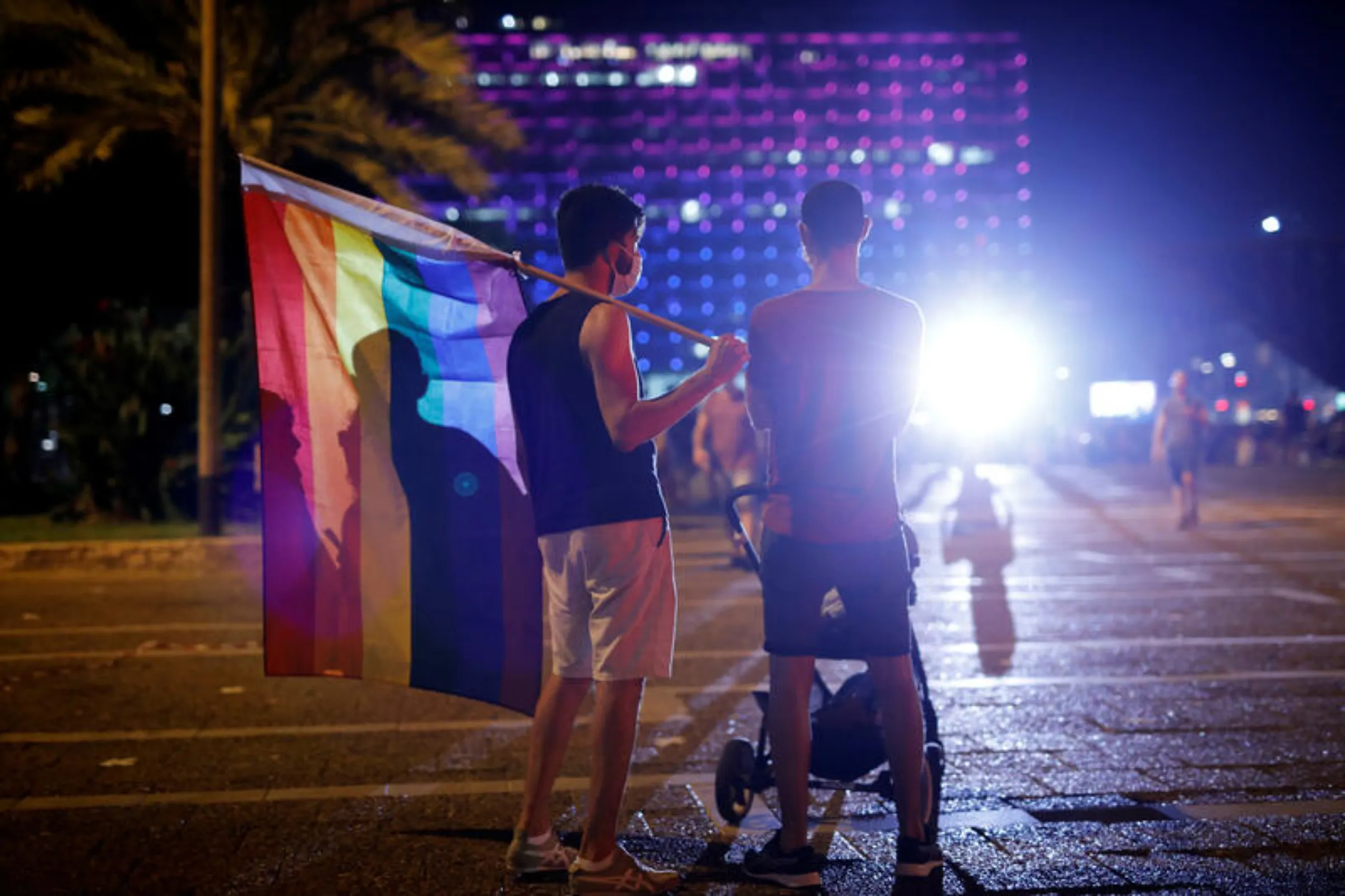 People hold a rainbow flag as they stand by a baby carriage during a Gay Pride event in Tel Aviv, Israel June 28, 2020. REUTERS/Amir Cohen