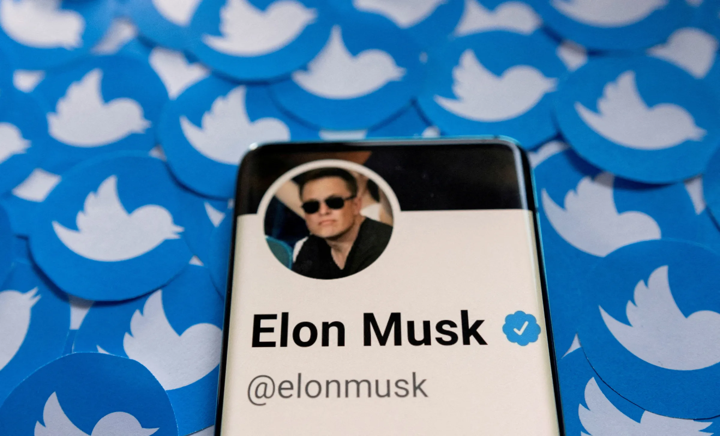 Elon Musk's Twitter profile is seen on a smartphone placed on printed Twitter logos in this picture illustration taken April 28, 2022