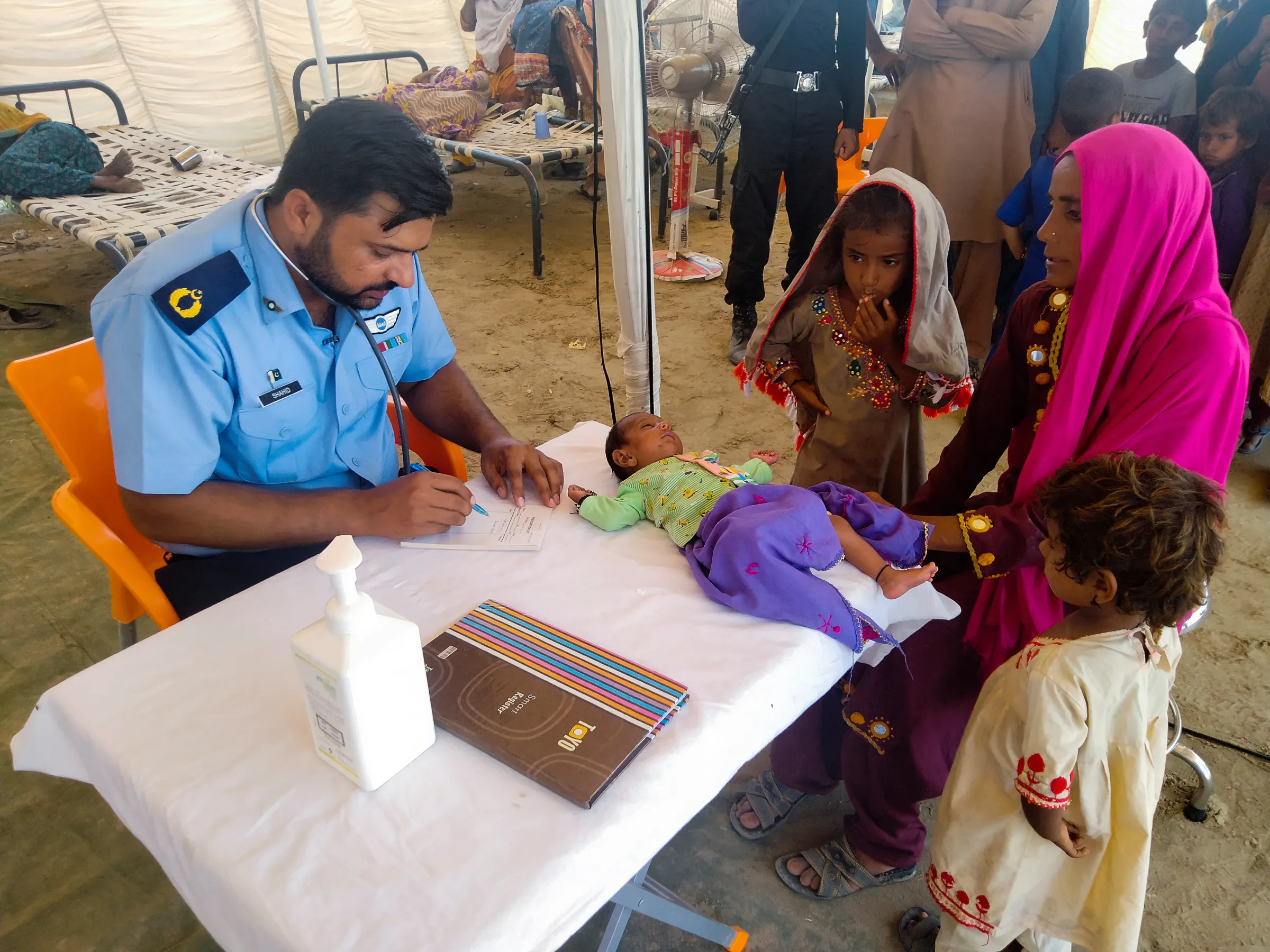 A woman, who is a flood victim, receives medical assistance for her baby as she takes refuge at a relief camp, following rains and floods during the monsoon season in Sehwan, Pakistan September 9, 2022